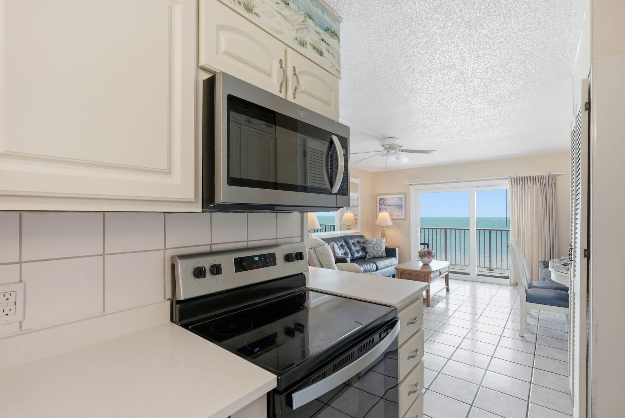 The Summit 830 – Bright, open kitchen and living area with ocean view and tile flooring.