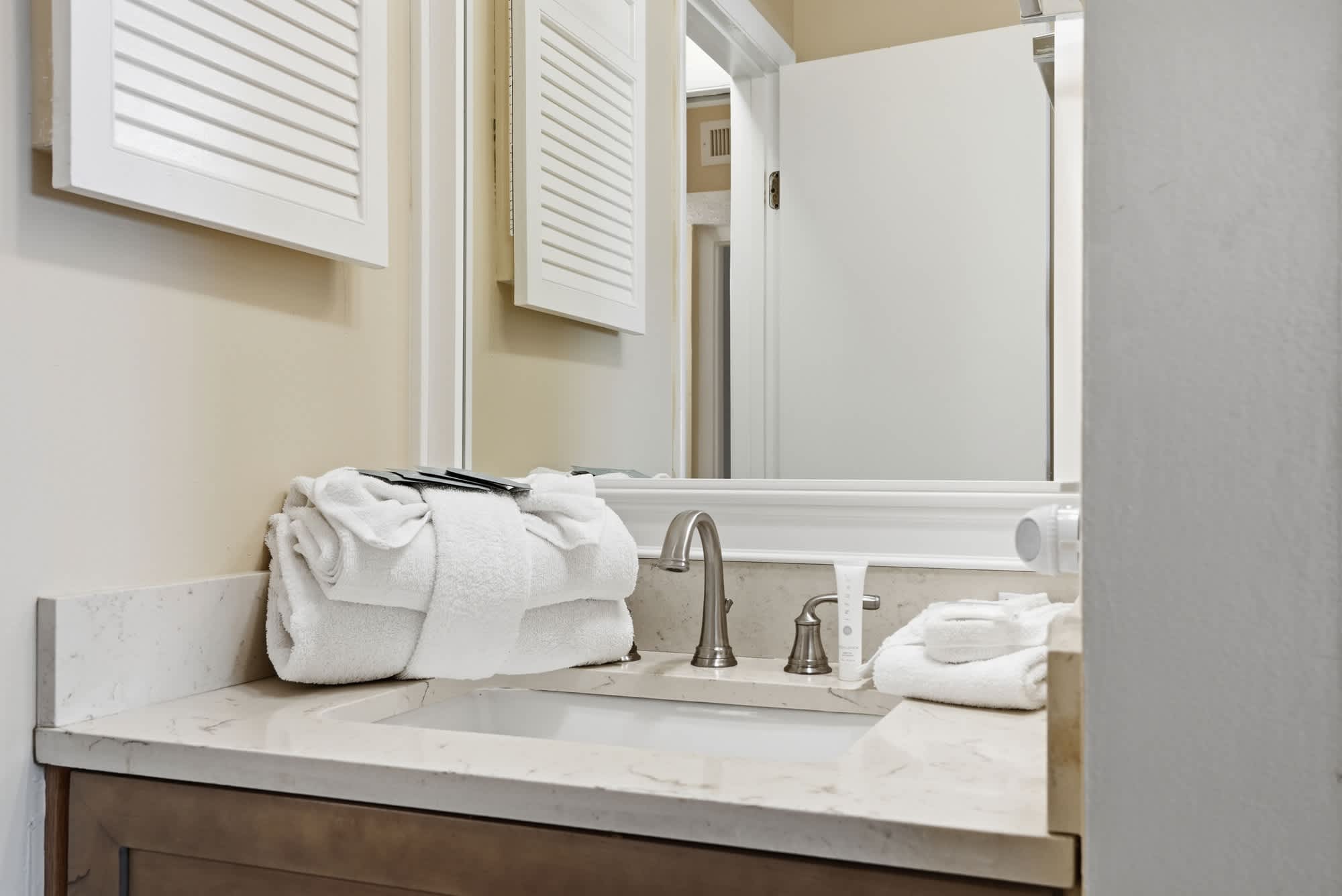The Summit 830 – Bathroom countertop with sink, towels, and toiletries, featuring a mirror and light-colored walls.