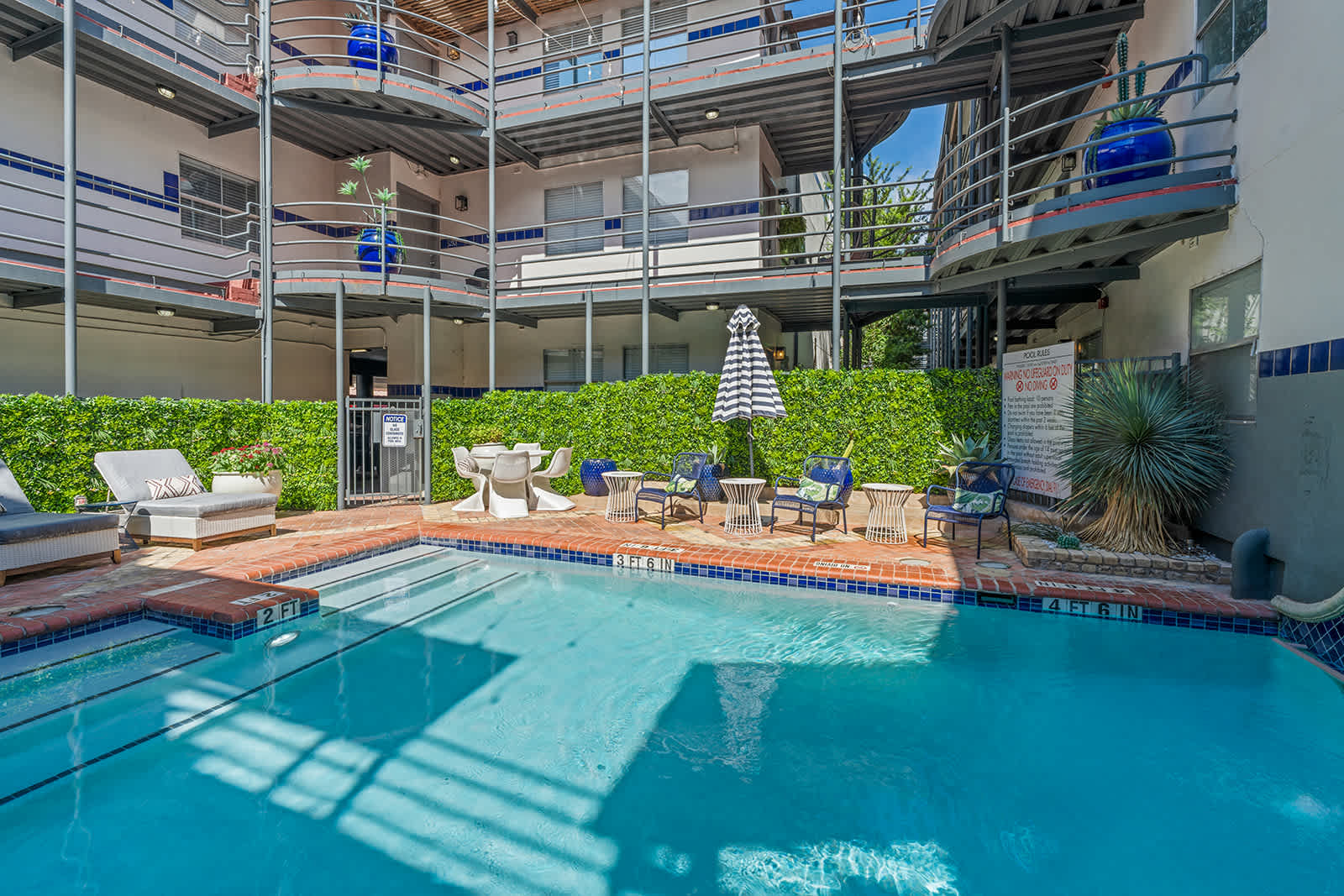 Relax by the sparkling pool with ample seating and lush greenery, perfect for unwinding after a day of exploring.