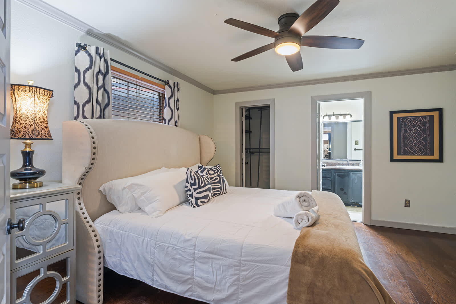 Relax in this cozy bedroom featuring elegant decor and a private ensuite bathroom.