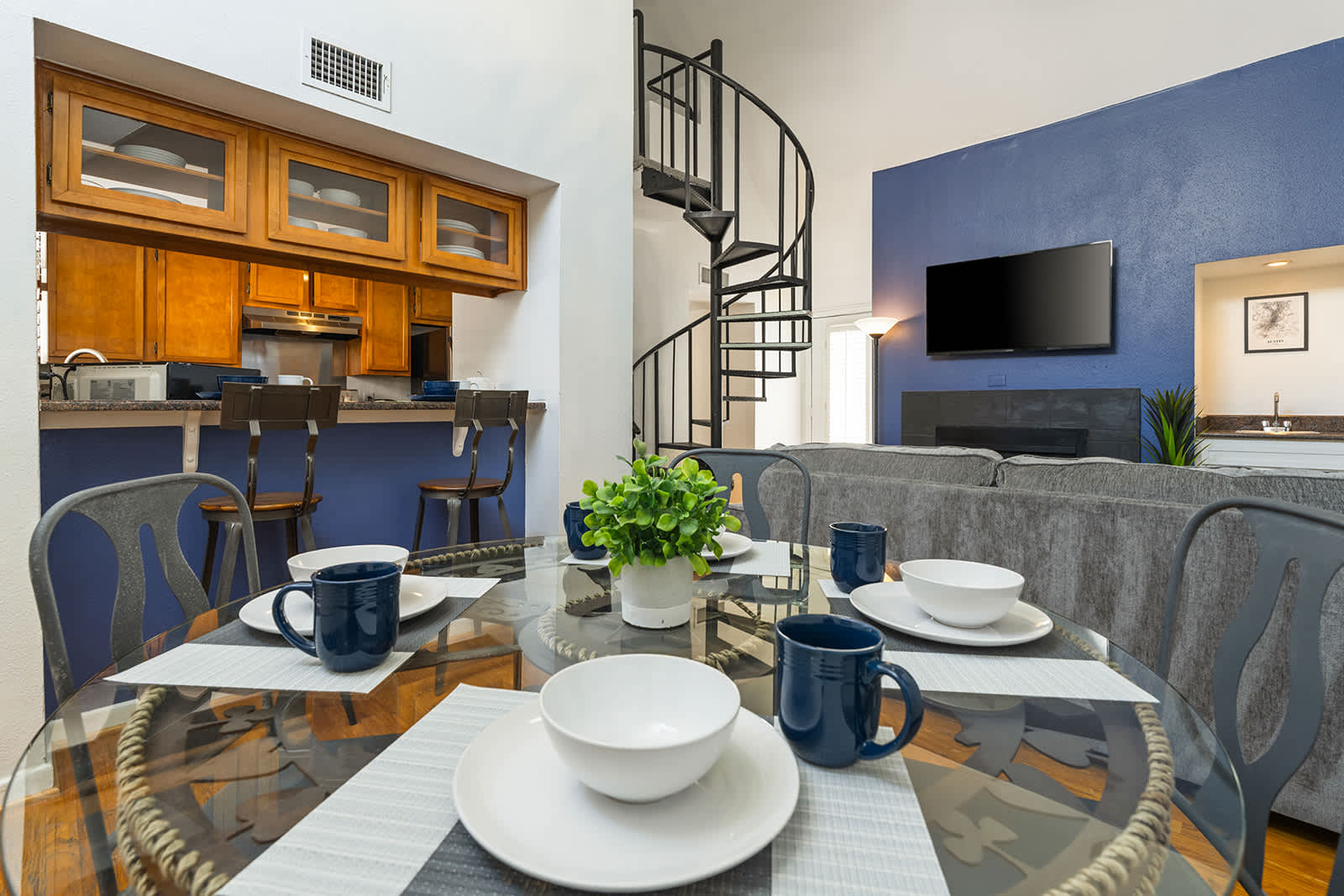 Spacious living area with stylish spiral staircase and modern amenities, perfect for relaxing or entertaining.
