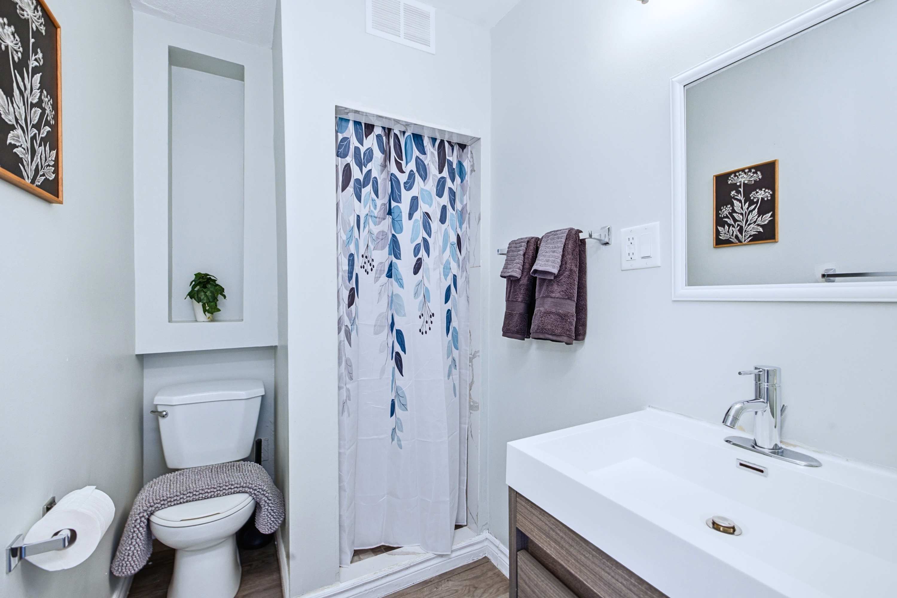 Bright bathroom with a shower, toilet, and vanity sink