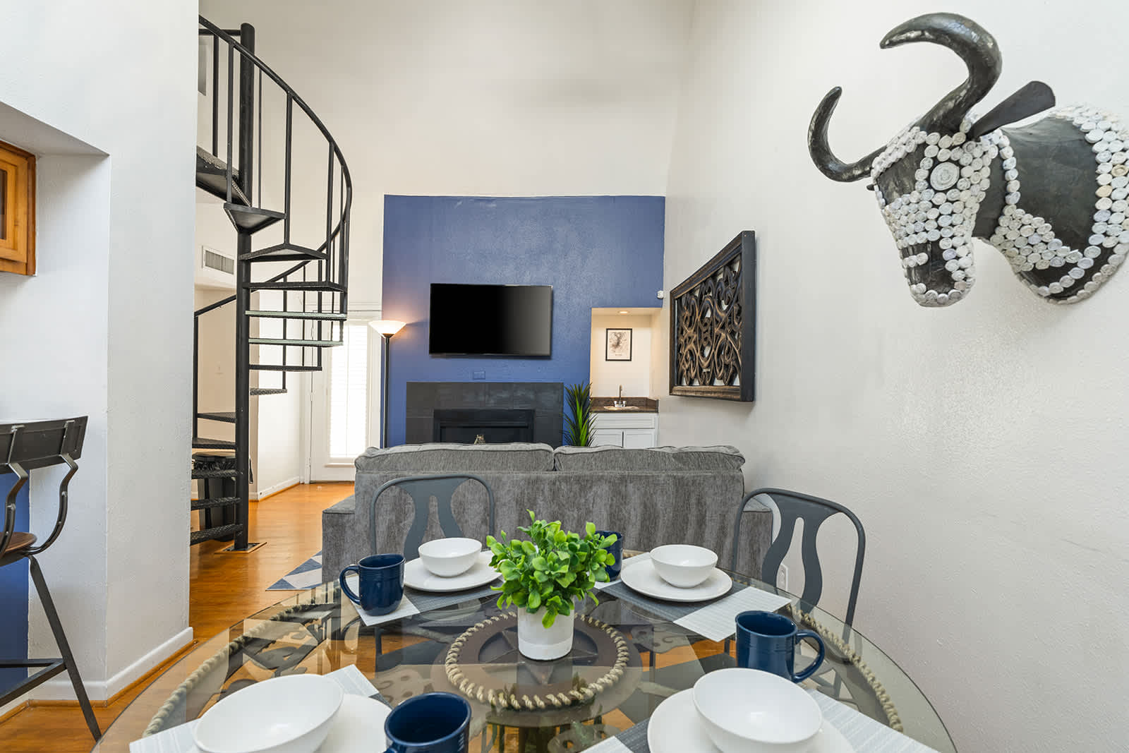 Chic living space with spiral staircase and cozy fireplace, perfect for relaxation and entertainment.