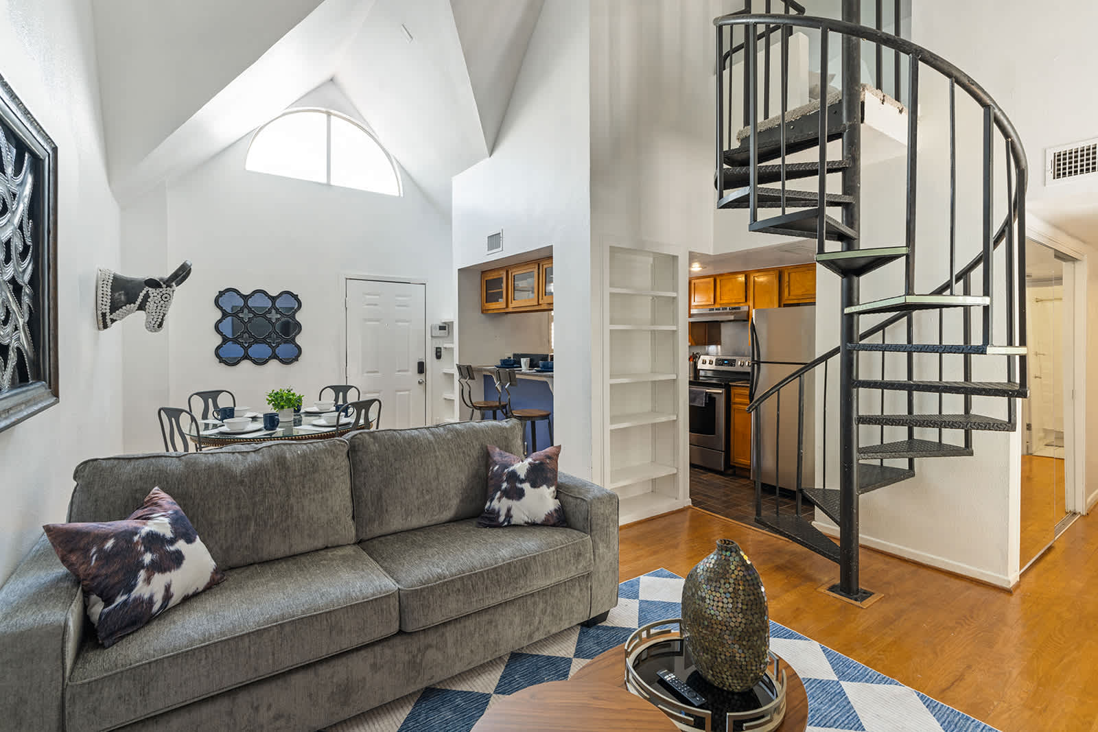 Charming living space with a spiral staircase and modern decor, perfect for relaxation and dining.