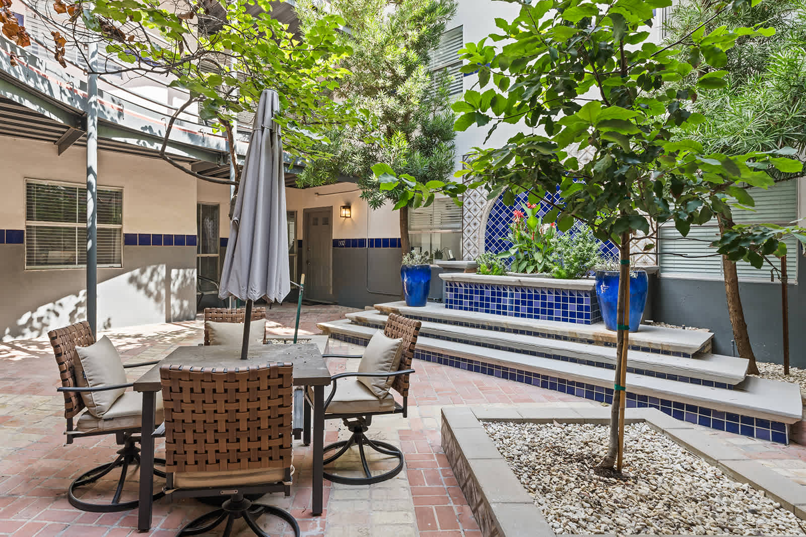 Relax in this charming outdoor patio with lush greenery and a beautiful fountain, perfect for unwinding.