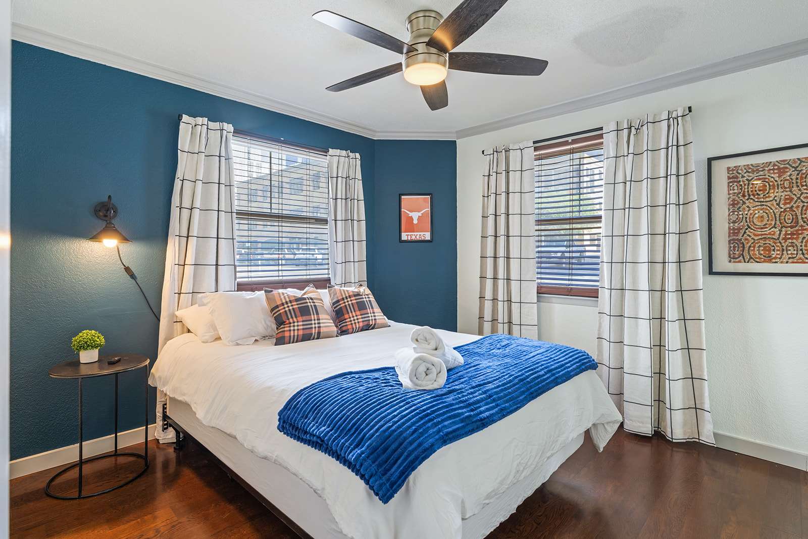 Relax in this stylish bedroom with cozy bedding, chic decor, and ample natural light for a restful stay.