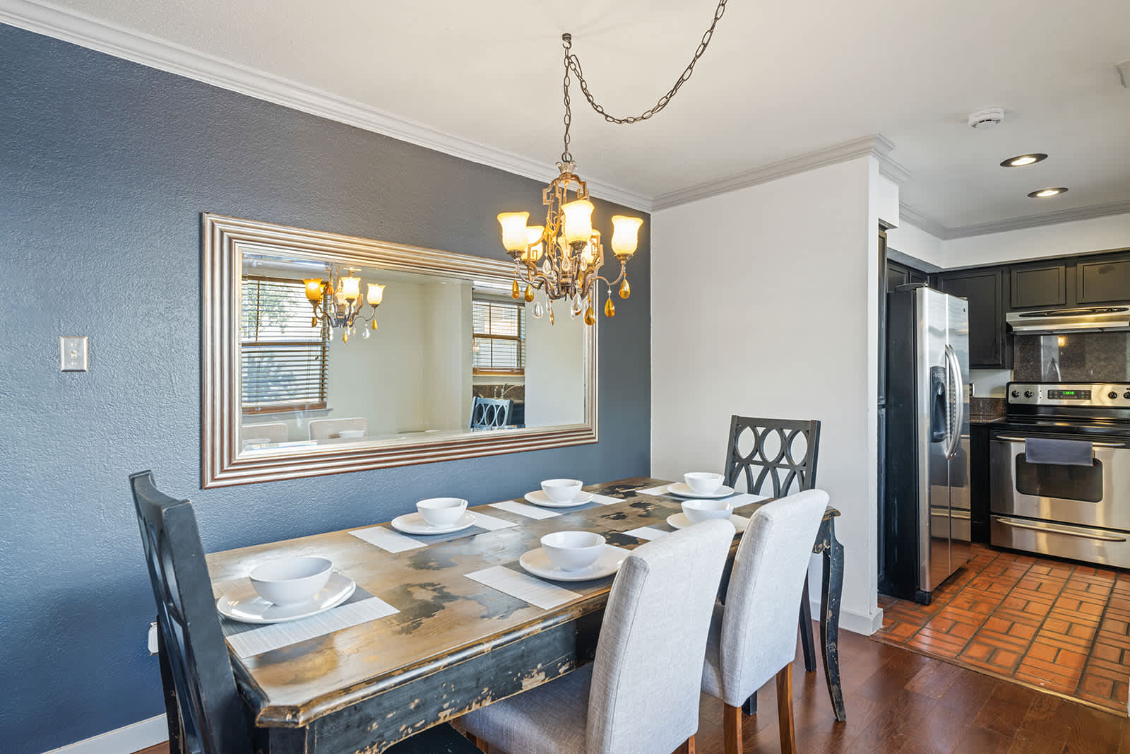Charming dining area with rustic table and elegant chandelier, perfect for family meals.