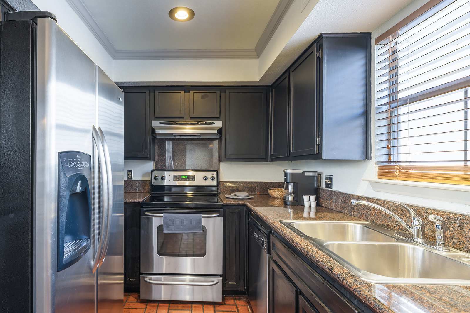 Modern kitchen with sleek stainless steel appliances and granite countertops, perfect for culinary enthusiasts.