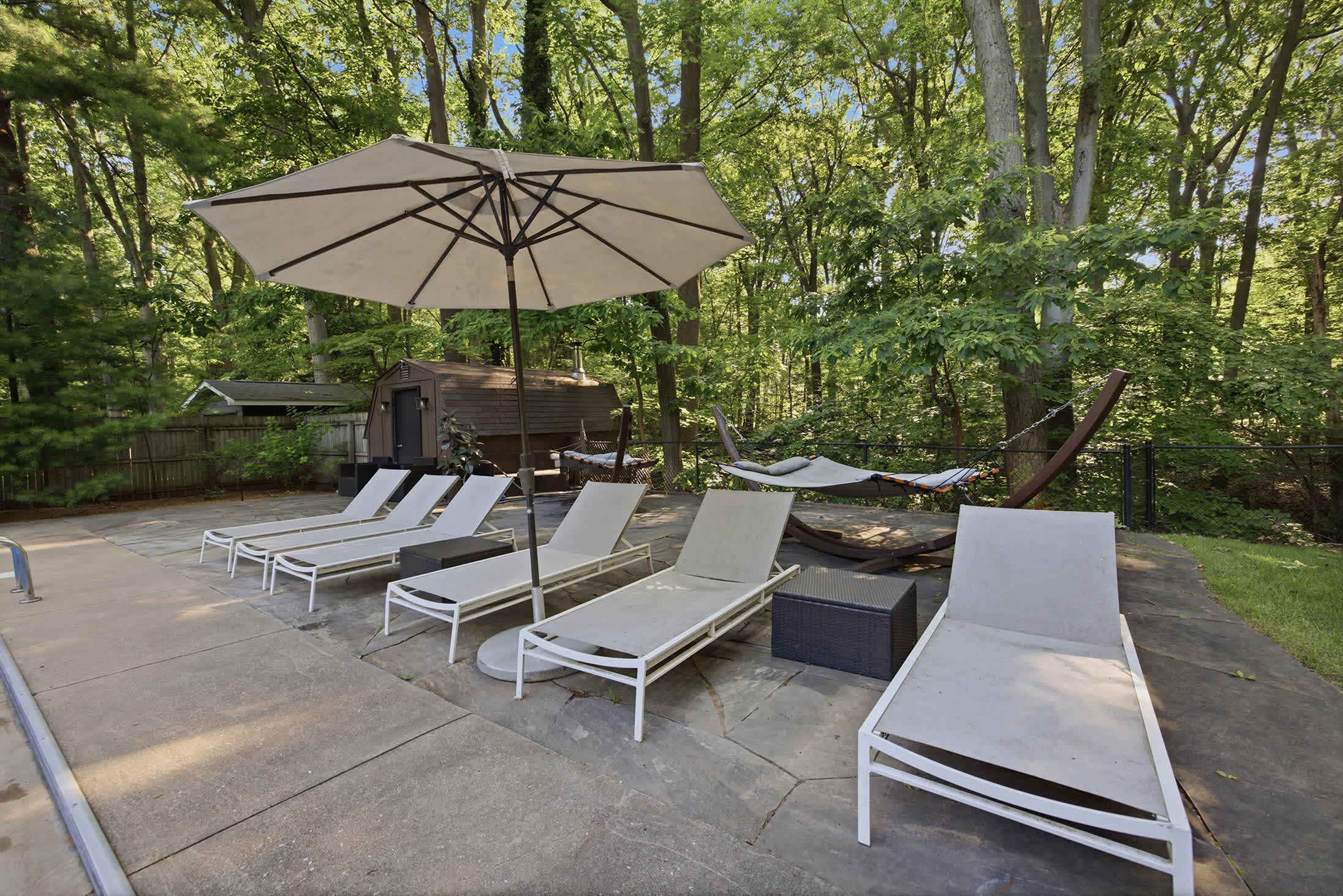 A serene lounging spot tucked into the home’s lush woodland setting.