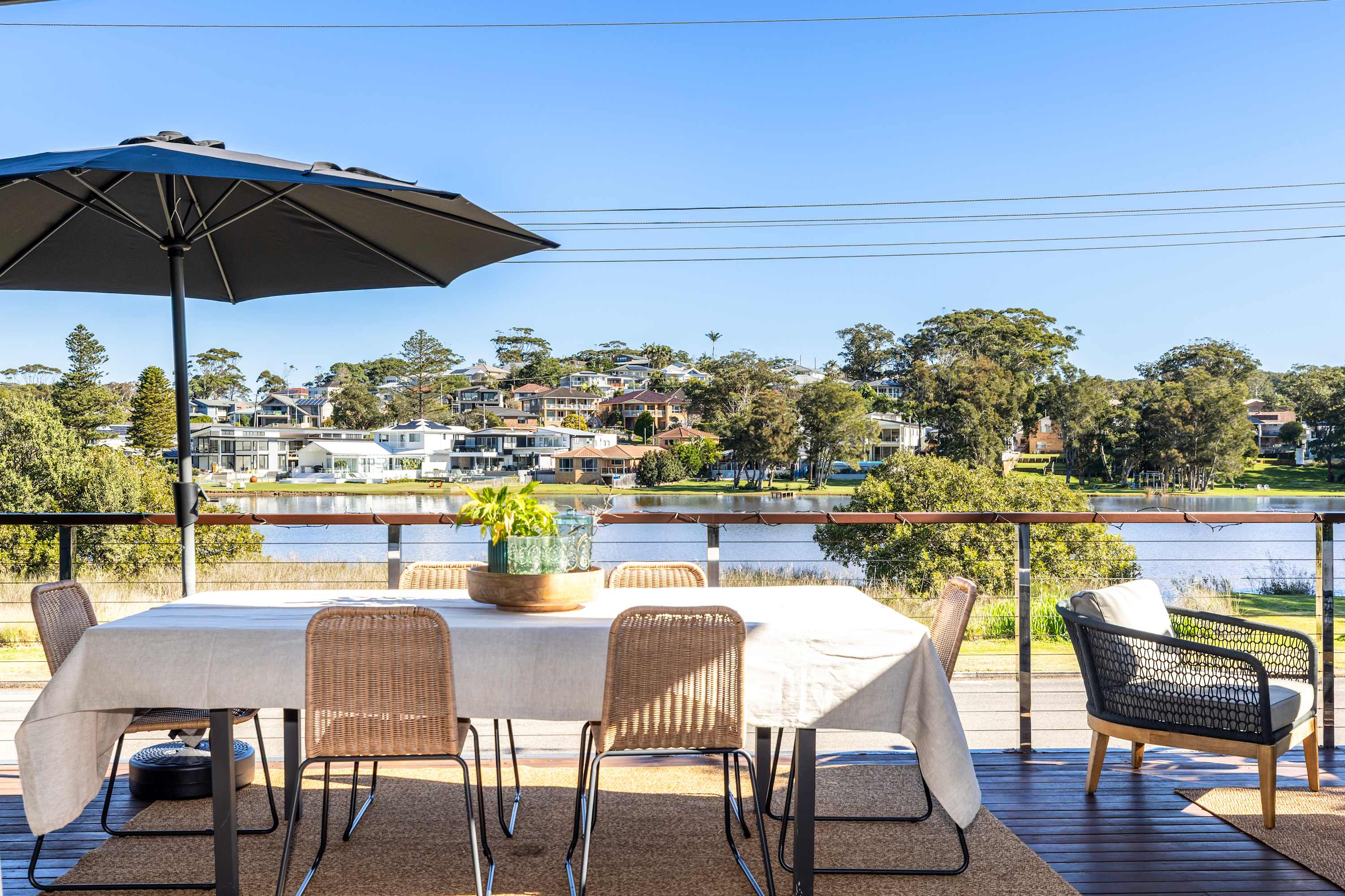 Wamberal Lagoon in the backyard. Terrigal Beach a five-minute walk. Welcome to Lake House. Lake House is a beautifully designed split-level home in Wamberal’s coveted Golden Triangle — a rare lakefront position with direct water access, a glass floor that stops guests mid-step, bi-fold doors opening to a covered lake-view terrace, and the golden sands of Terrigal Beach and the Esplanade café strip just five minutes on foot. For large families and groups who want the lake, the beach, and the best of Terrigal without ever needing the car, there is nowhere else like this on the Central Coast.