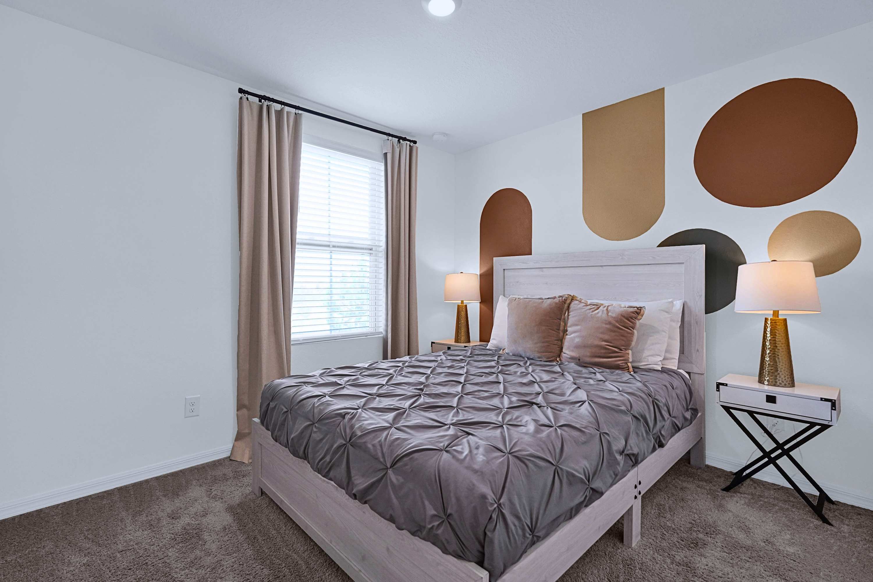 A beautifully prepared queen bed with soft linens and warm bedside lighting