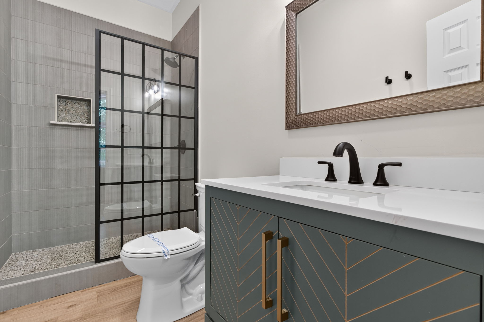 Freshen up in a bathroom featuring chic gray tones and gold accents.