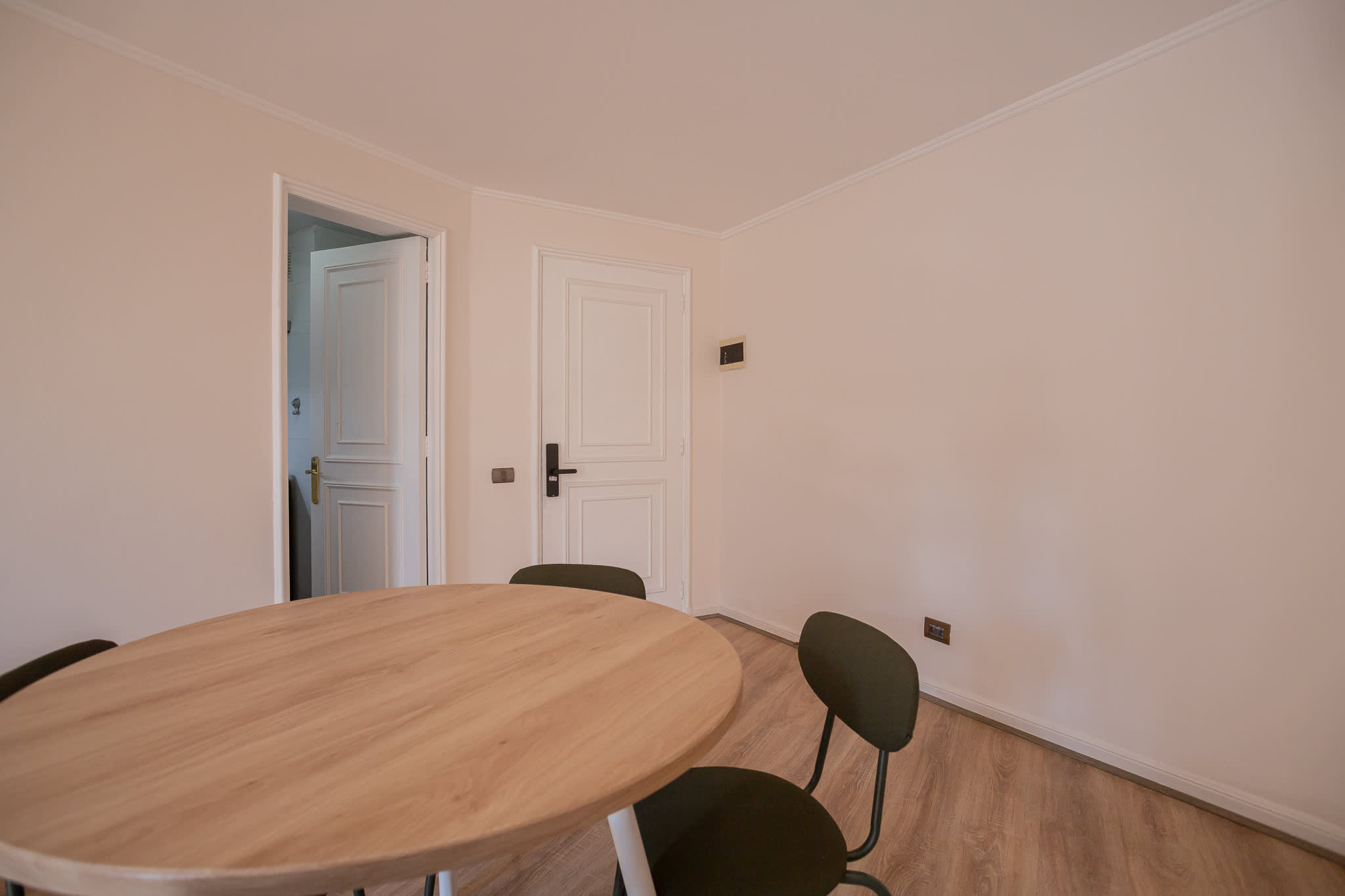 Dining area with a spacious light-wood table and four chairs, ready for relaxed meals in the apartment.
