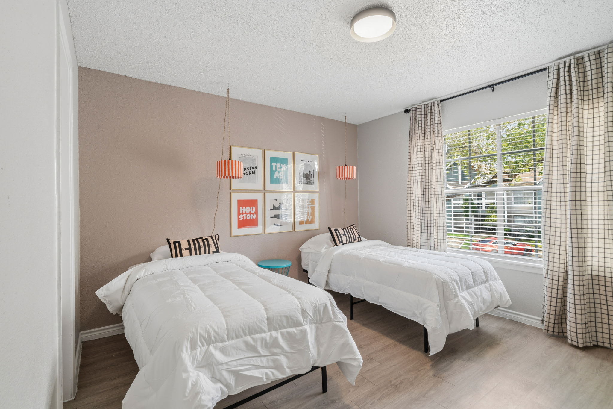 Cozy bedroom with twin beds, modern decor, and ample natural light for a restful stay.
