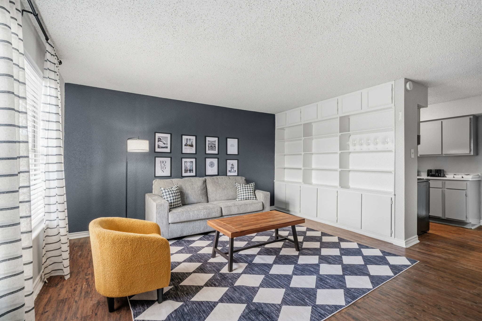 Stylish living room with cozy seating and ample natural light, perfect for relaxation.