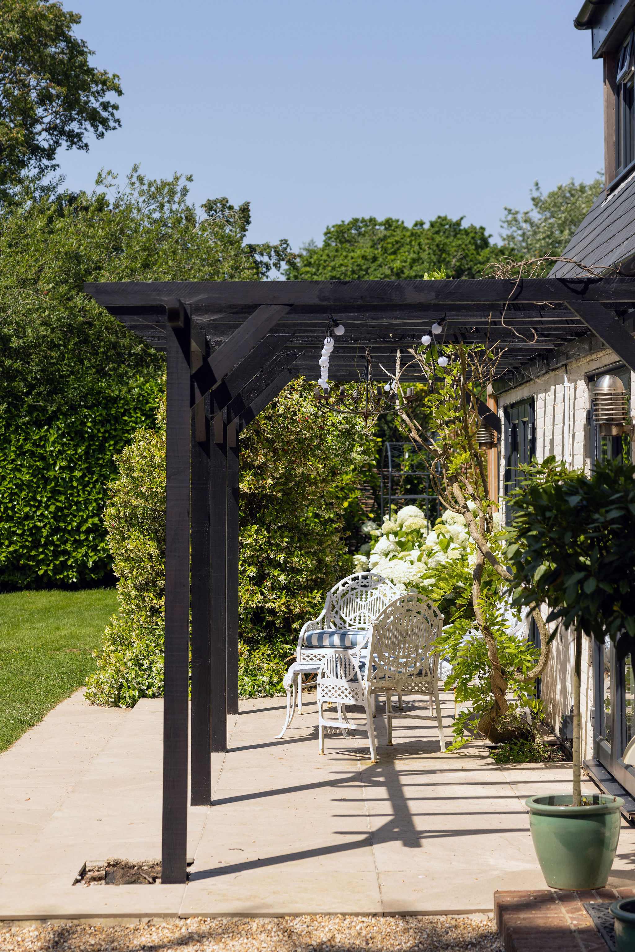 Covered patio framed by climbing greenery, creating a charming spot to unwind outdoors