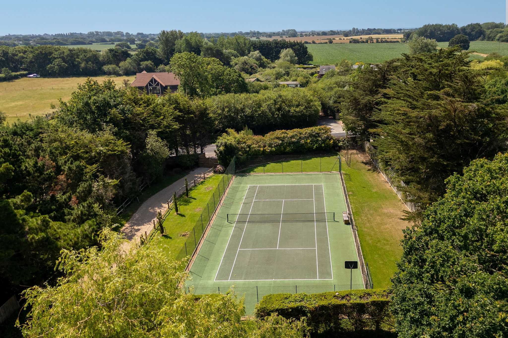 Private tennis court surrounded by scenic countryside, perfect for active family holidays and friendly matches