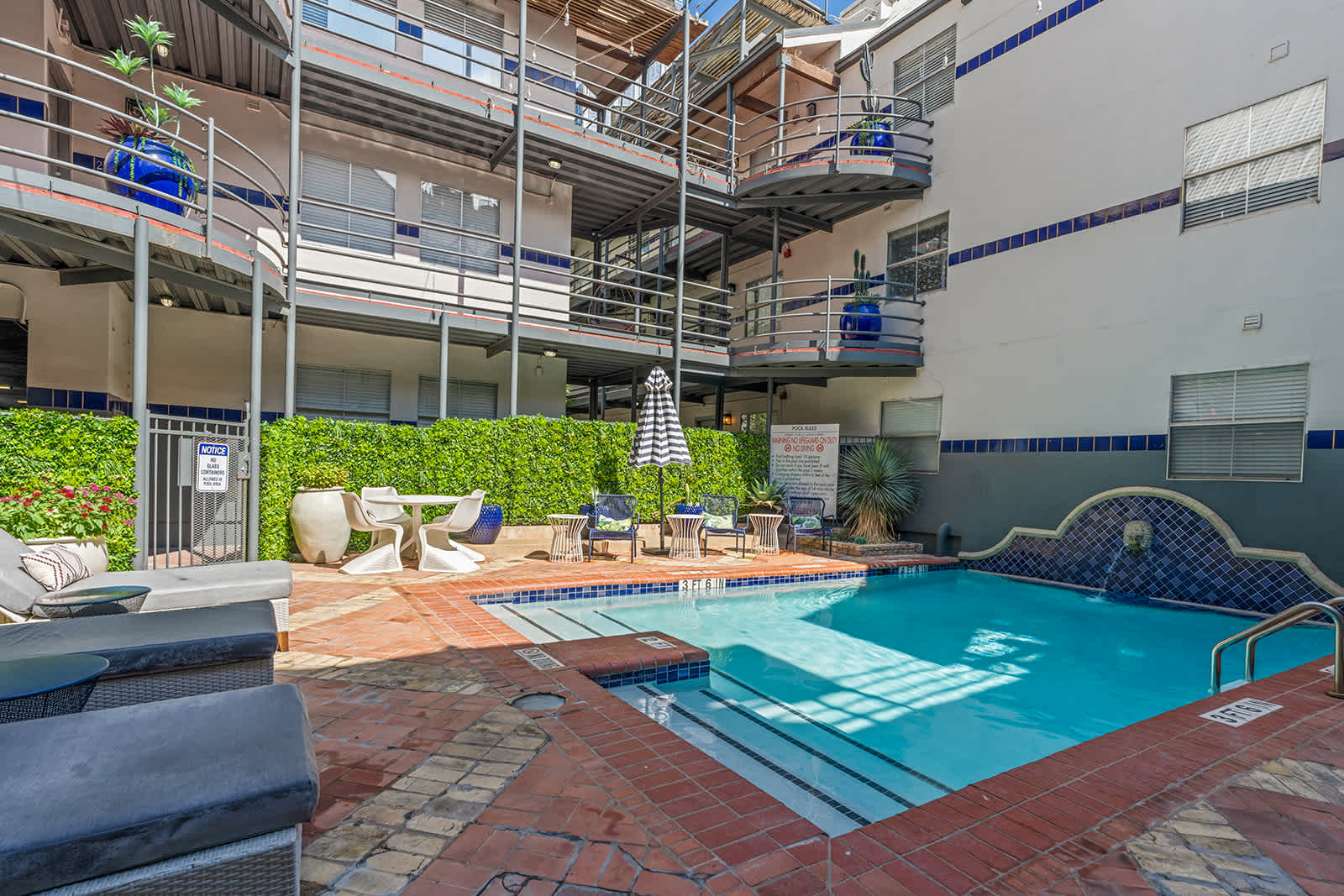 Relax by the inviting poolside with comfortable seating and lush greenery, perfect for unwinding after a day of exploring.