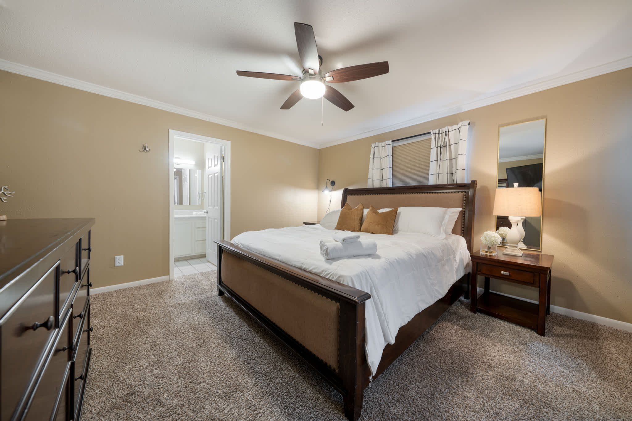 Relax in this cozy bedroom featuring a plush king-sized bed and warm lighting, perfect for a restful night's sleep.