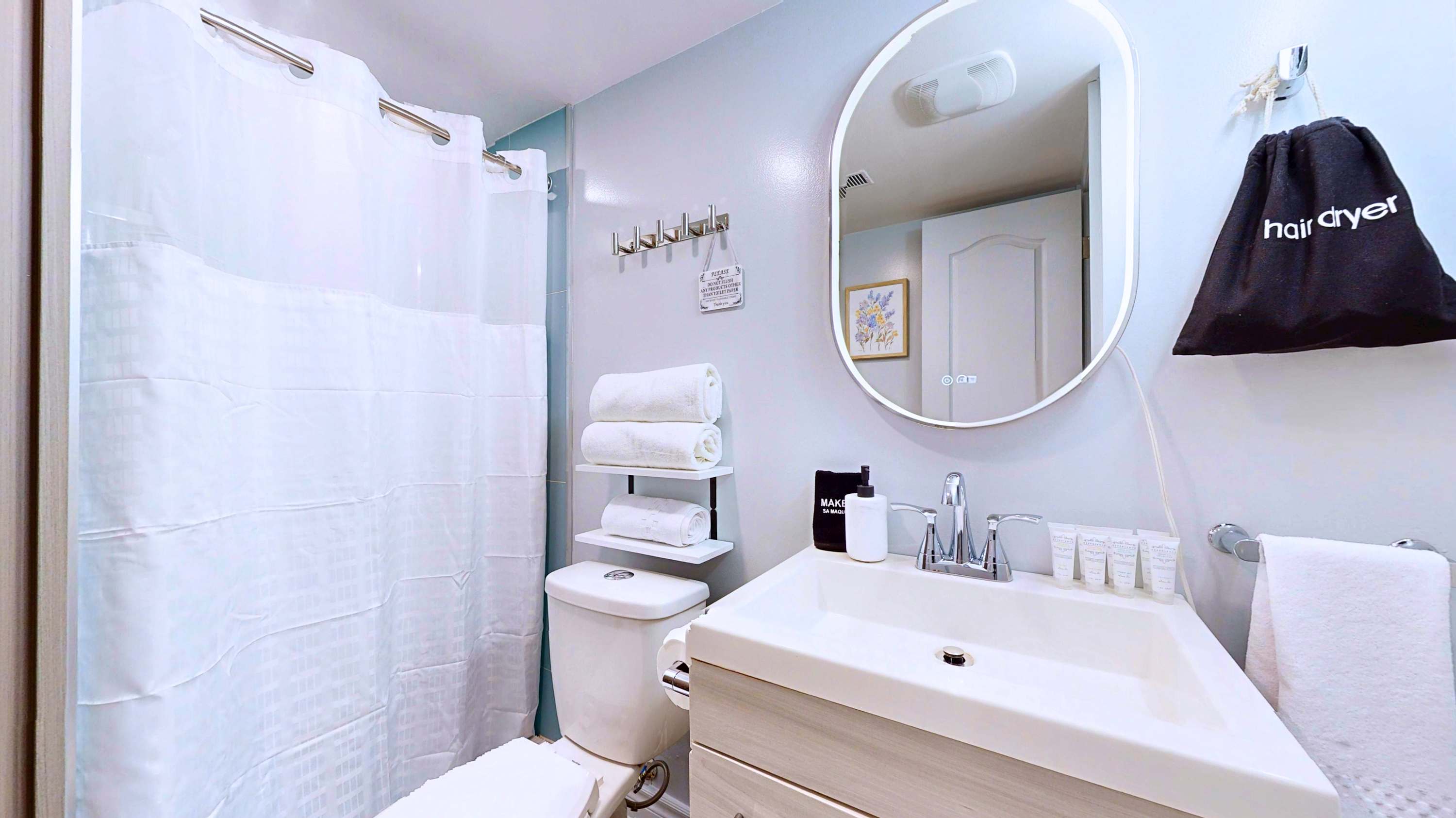 Cozy bathroom with a well lit mirror toilet and a clean shower setup with curtain