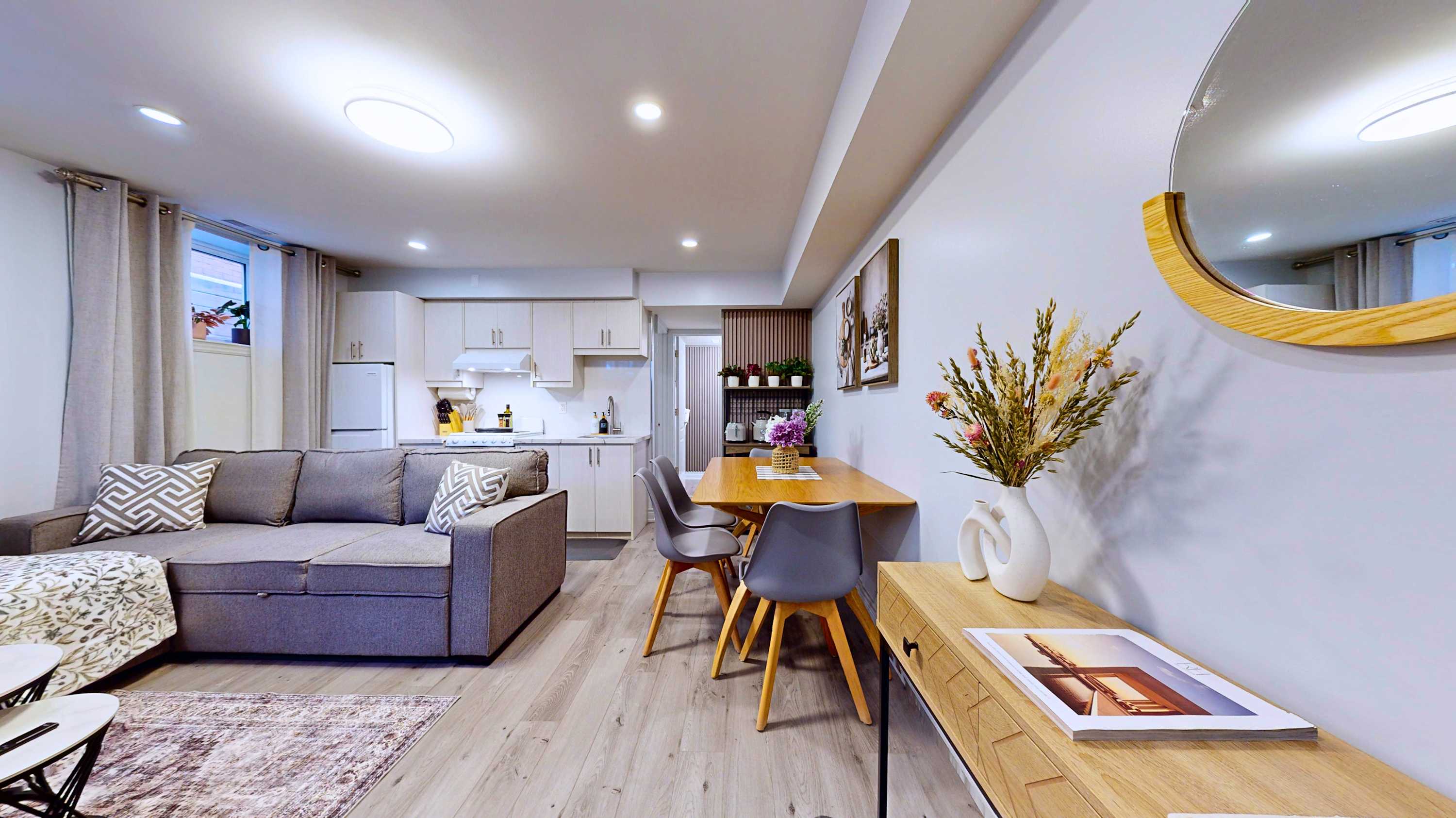 Perfect first view of the unit showing the entryway mirror dining setup cozy lounge and kitchen layout