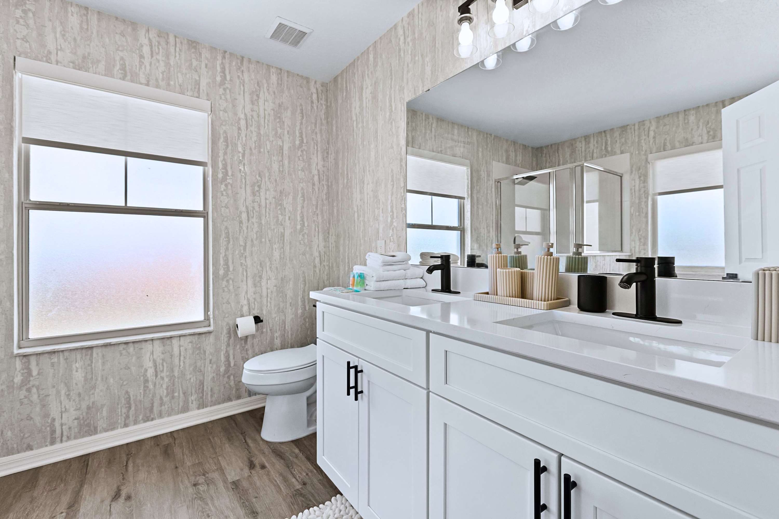 No morning rush here. A beautifully bright bathroom featuring a double vanity so everyone has plenty of space to get ready