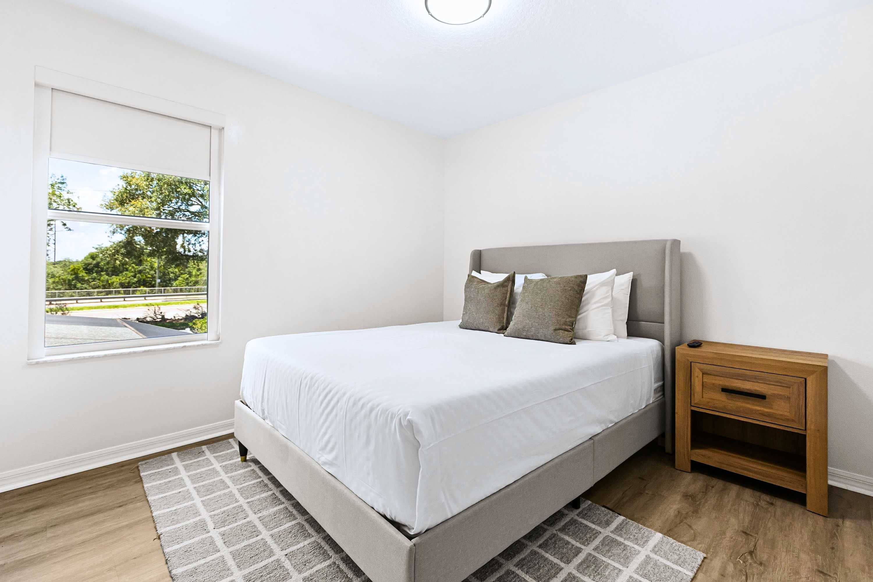 Wake up to beautiful natural light. A comfortable queen bed dressed in premium linens and framed by bright windows