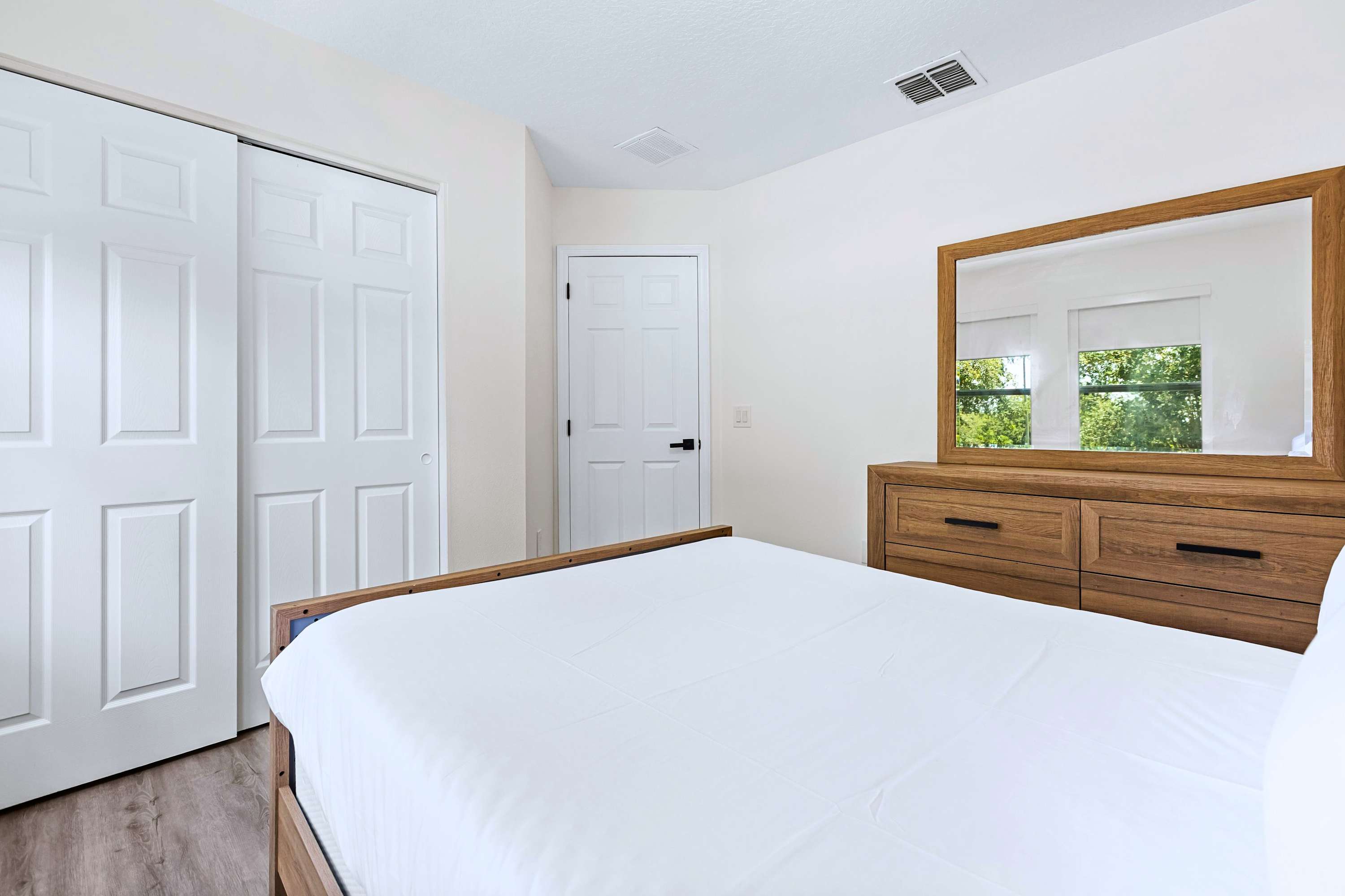 A cozy sanctuary with everything you need. Step out of bed and get ready easily at your stylish side dresser and mirror