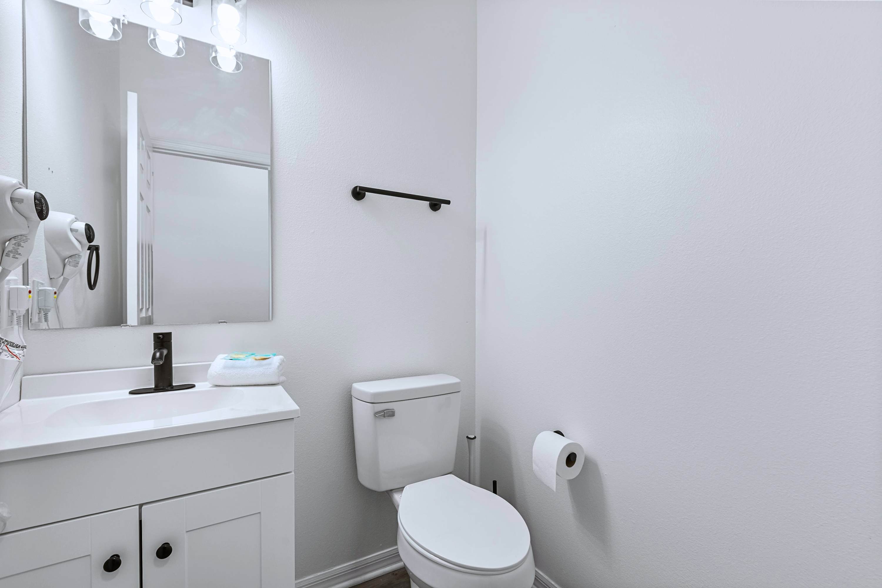 A beautifully bright and spotless powder room featuring a sleek mirror and sink to freshen up easily