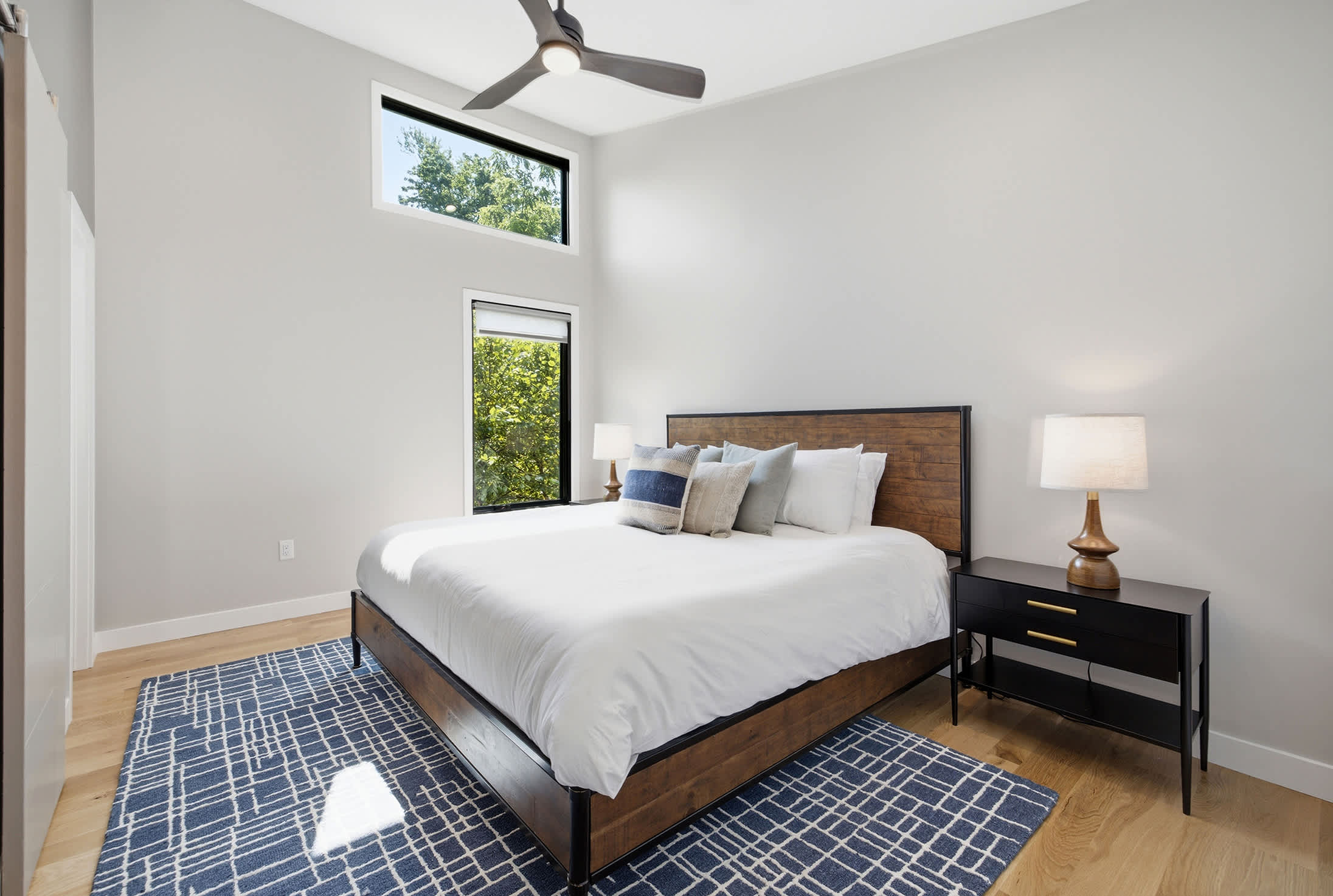 Soaring ceilings and oversized windows fill the main bedroom with natural light.