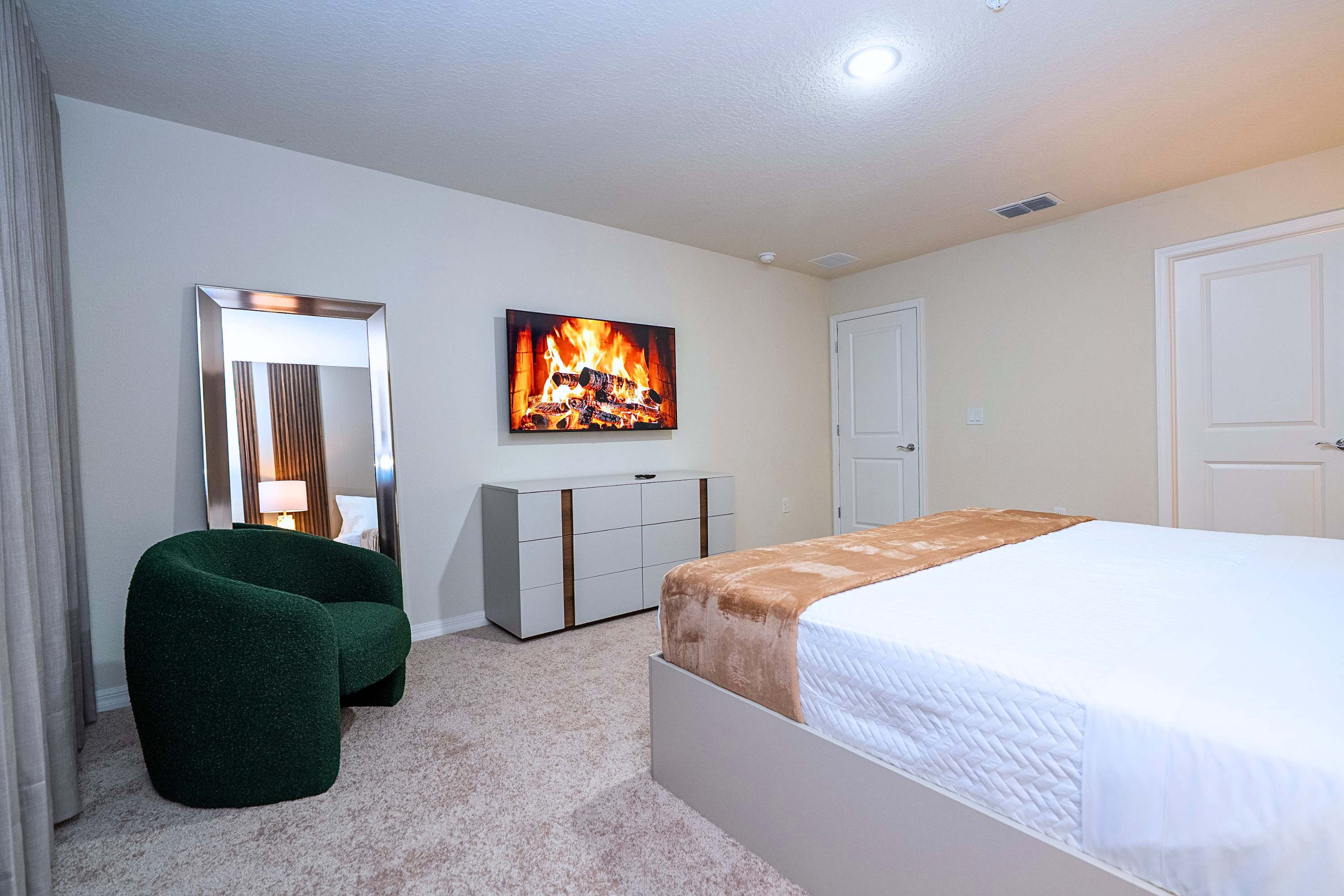 The ultimate suite view: a king bed, built-in TV, stylish accent lounge couch, and a room-brightening mirror