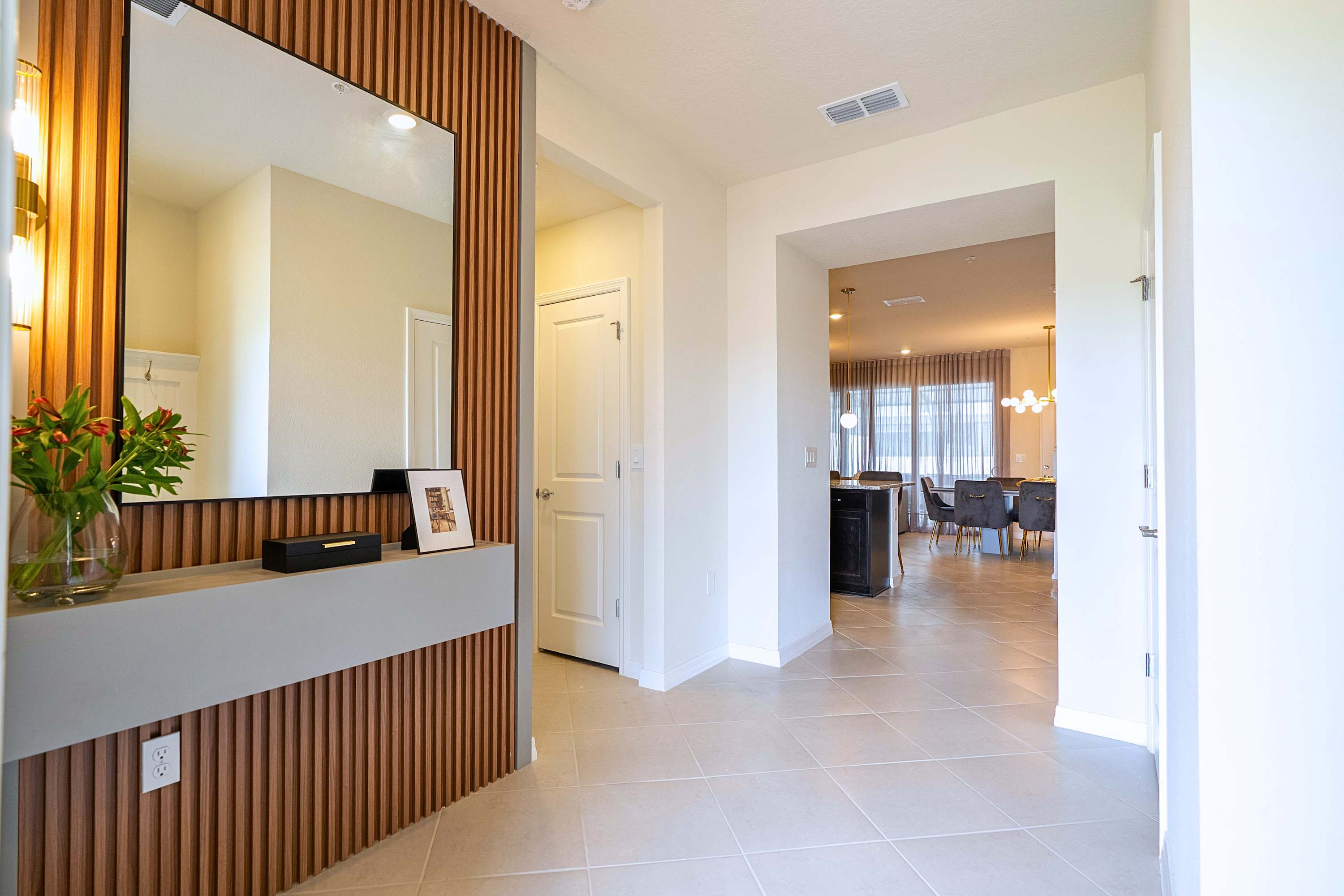 A welcoming room entrance featuring a large statement mirror that bridges the foyer directly to the main living area