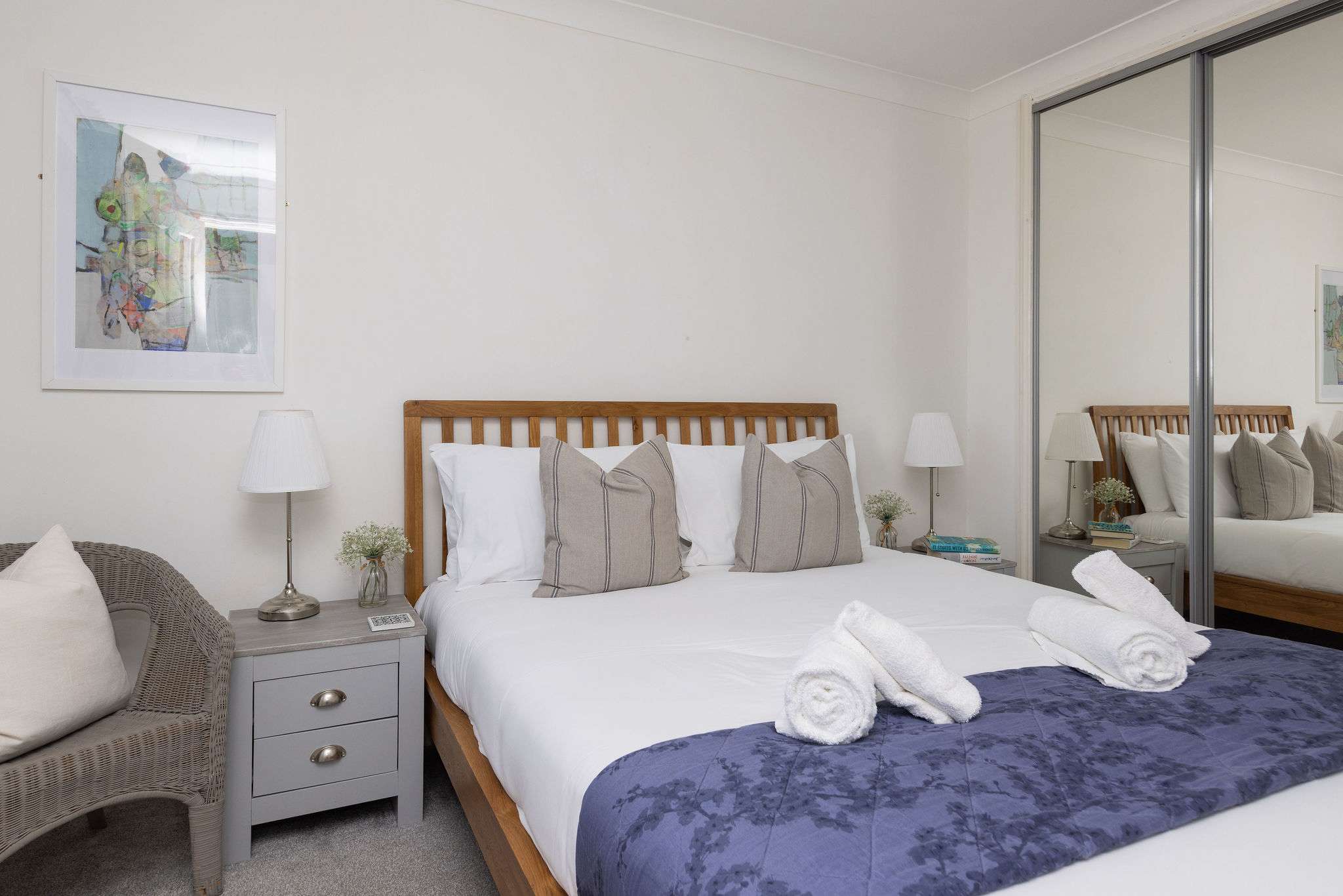 Bright and comfortable bedroom with mirrored wardrobes, offering a stylish and spacious retreat.