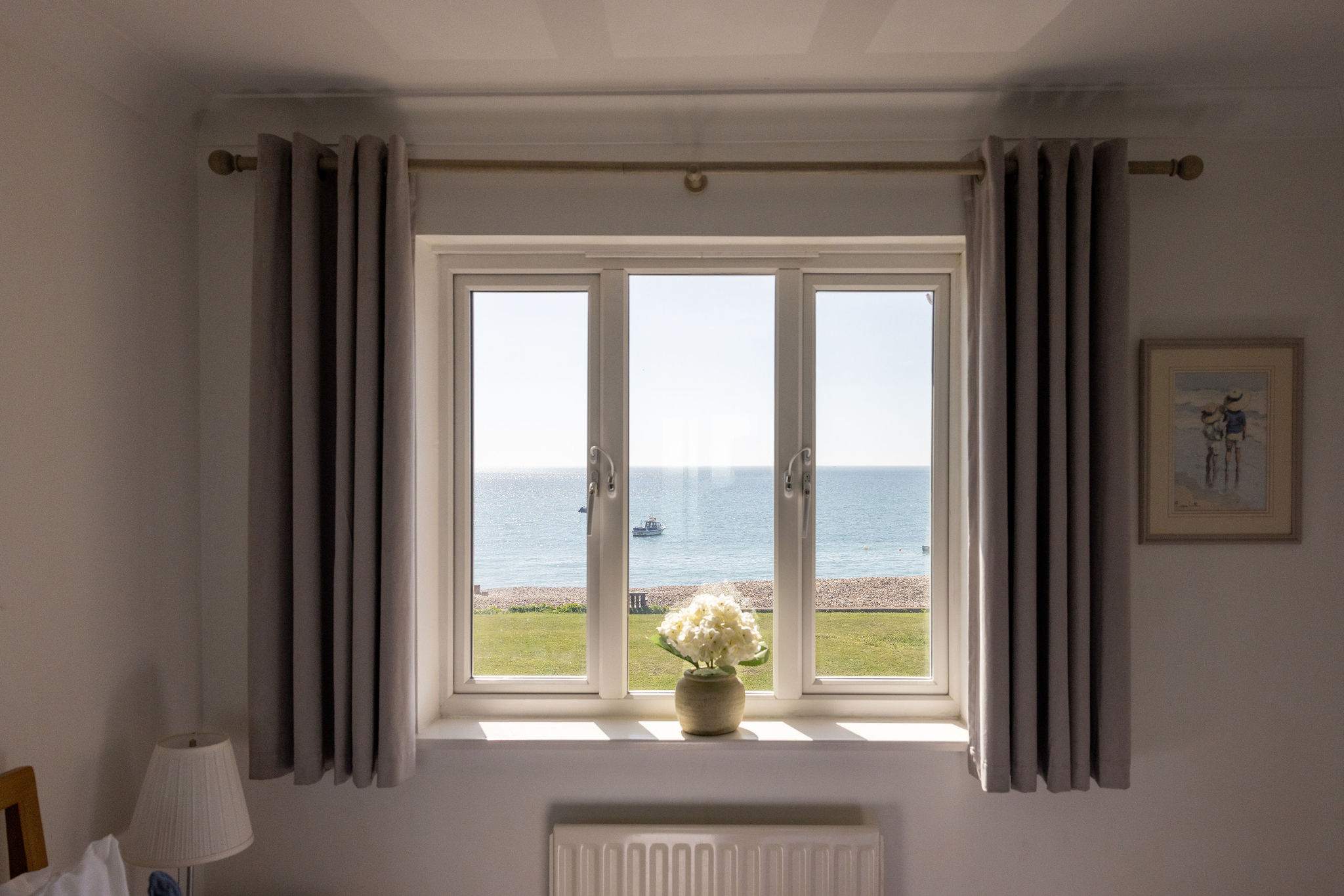 Wake up to panoramic ocean views from this peaceful beachfront holiday home bedroom.