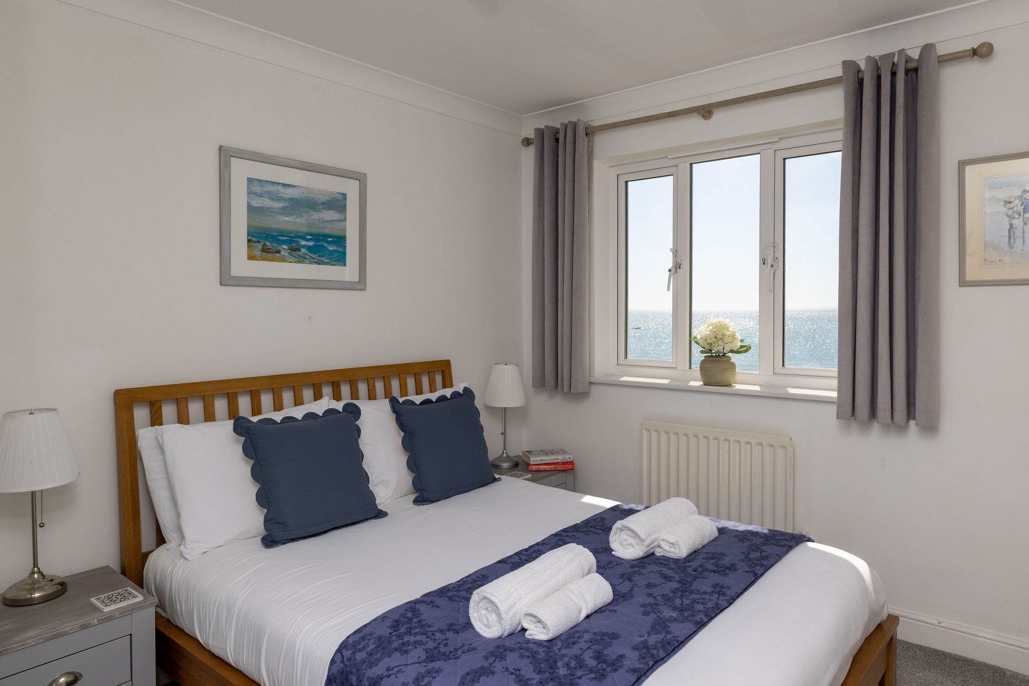 Bright double bedroom with calming décor and beautiful sea views for a relaxing coastal escape.