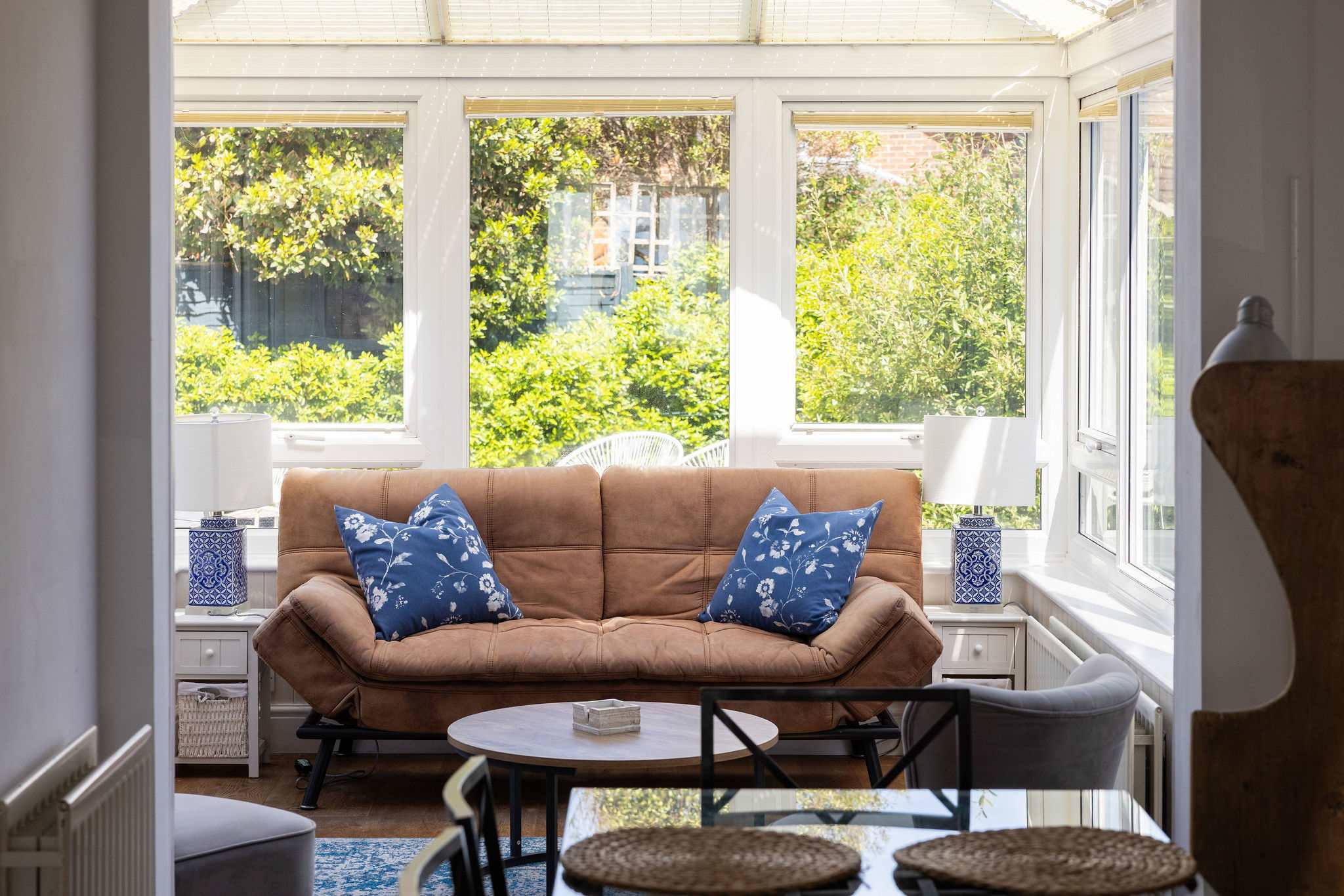 Bright conservatory with cosy seating, perfect for morning coffee and peaceful relaxation.