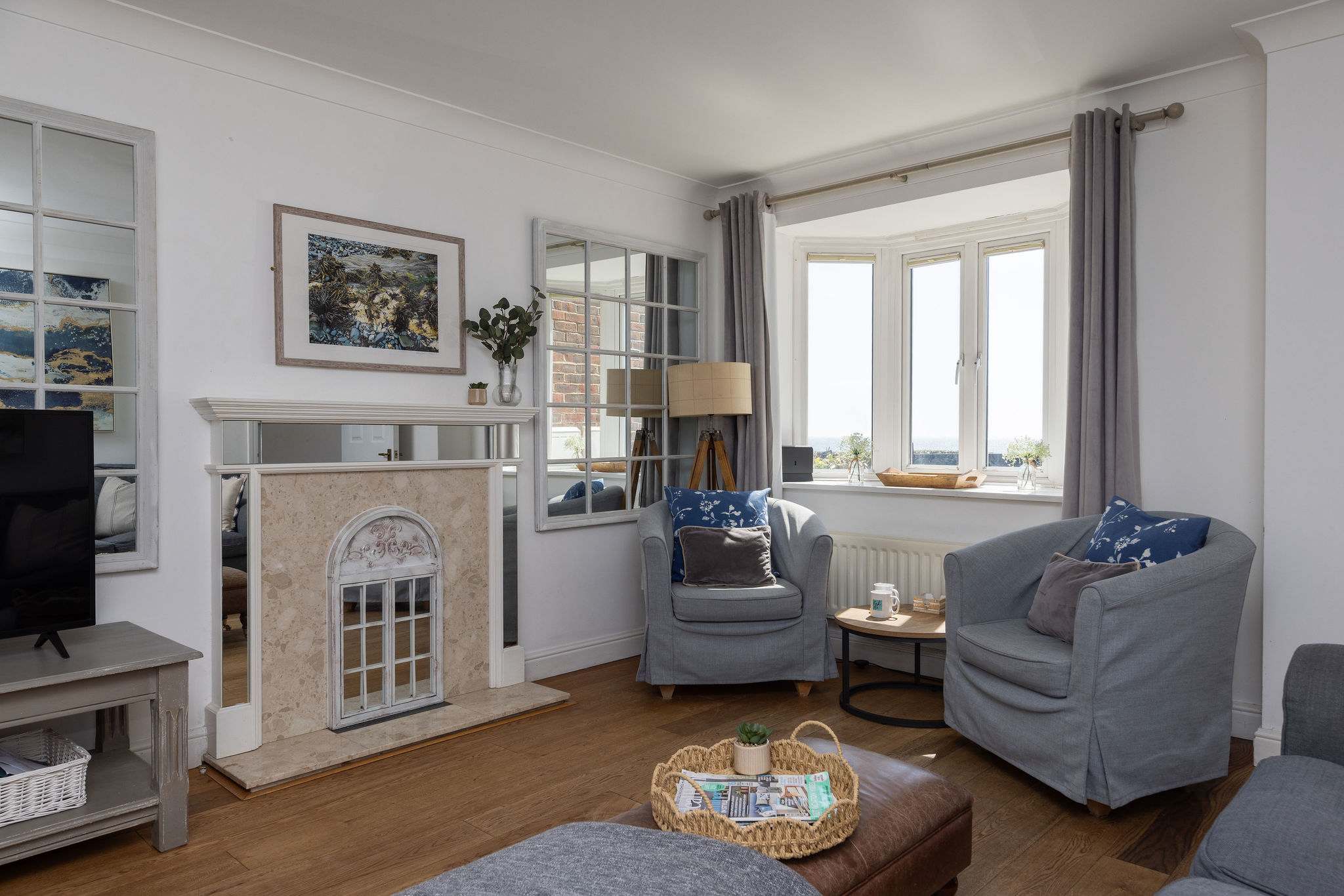 Bright and spacious living room with cosy seating and beautiful panoramic ocean views.