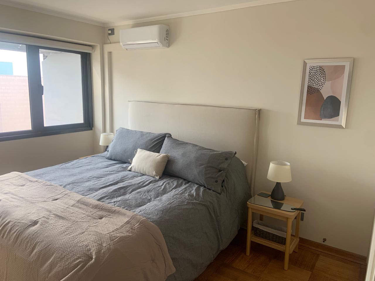 Relax in this cozy bedroom with natural light and stylish decor, perfect for a restful stay.