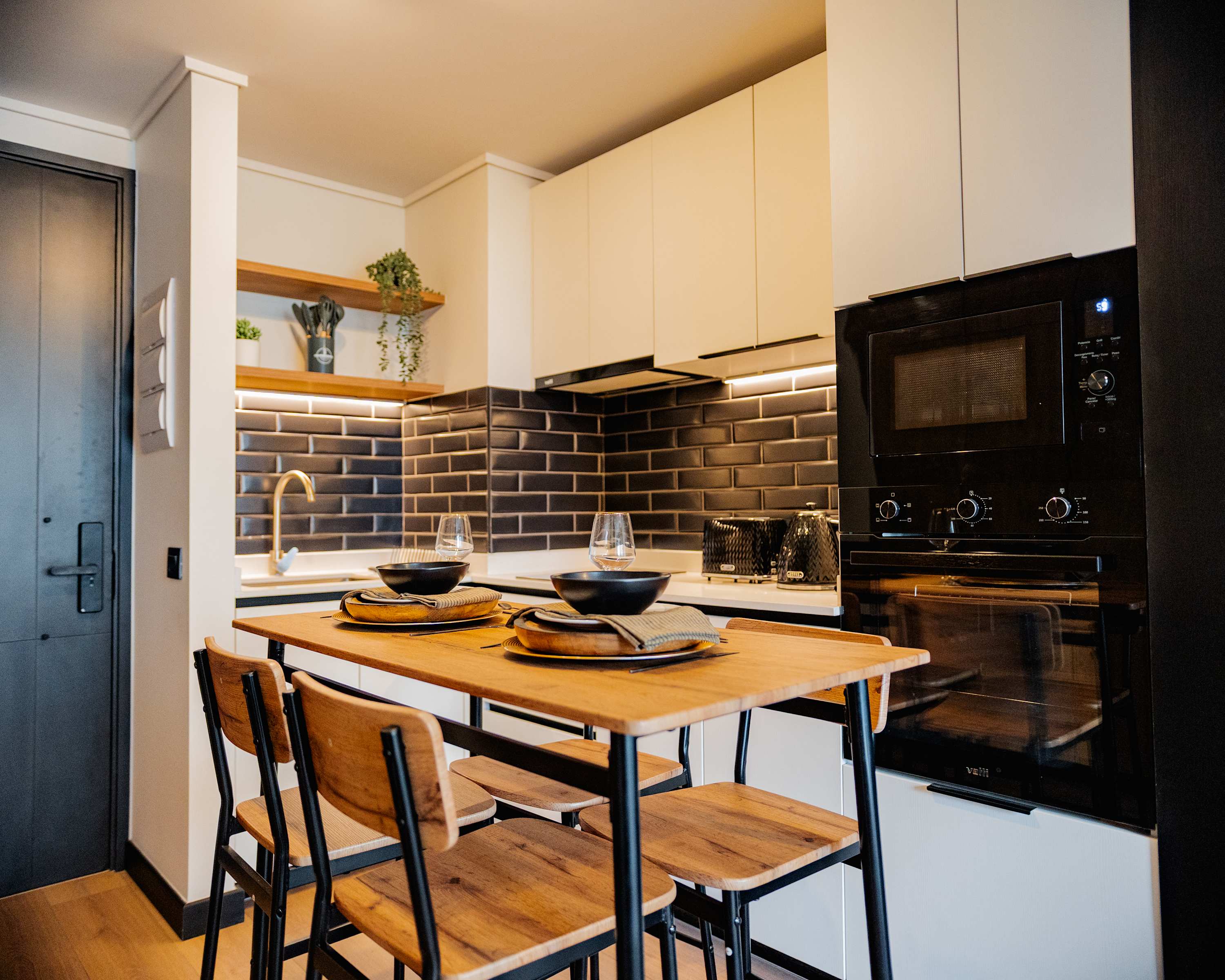 Stylish kitchen with modern appliances and cozy dining area, perfect for intimate meals.