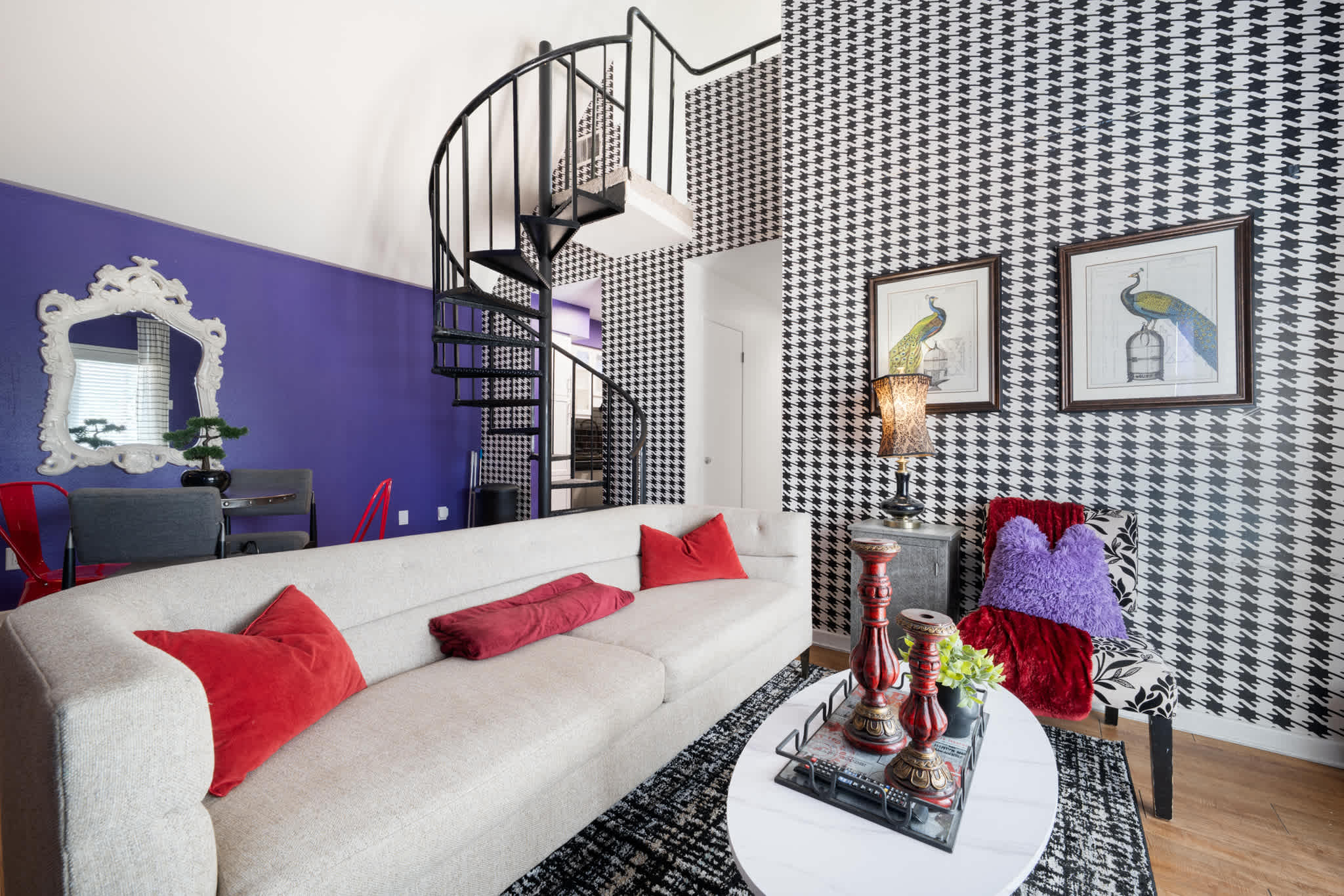 Chic living room with bold decor and a spiral staircase, perfect for relaxation and style.