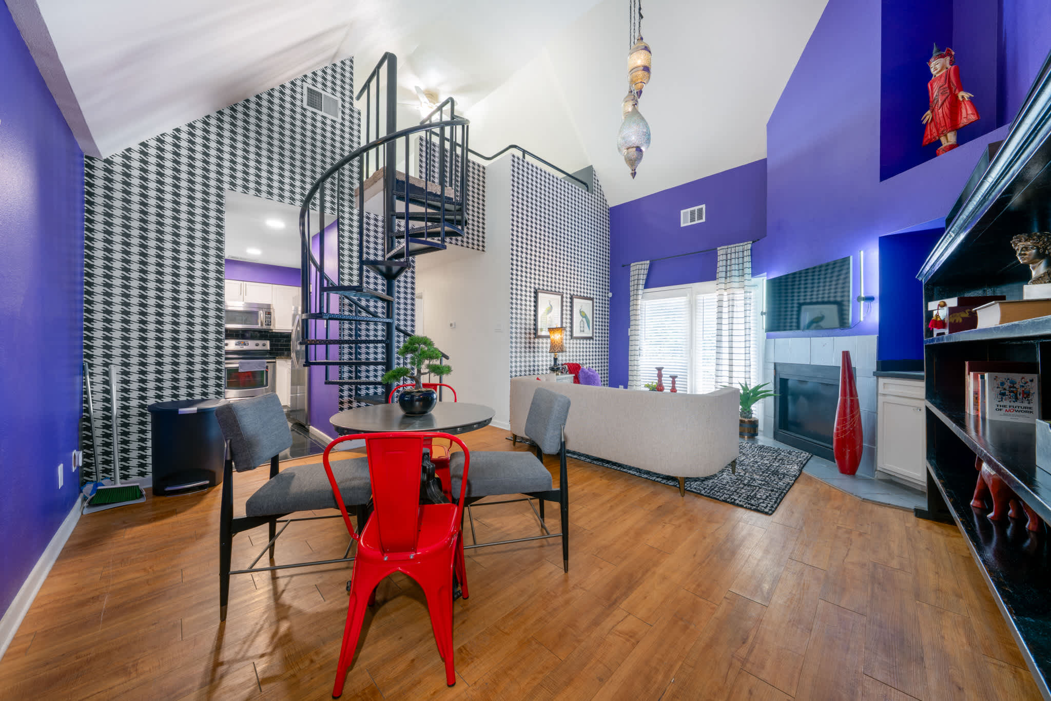 Experience modern elegance with a spiral staircase and cozy fireplace in this vibrant living space.