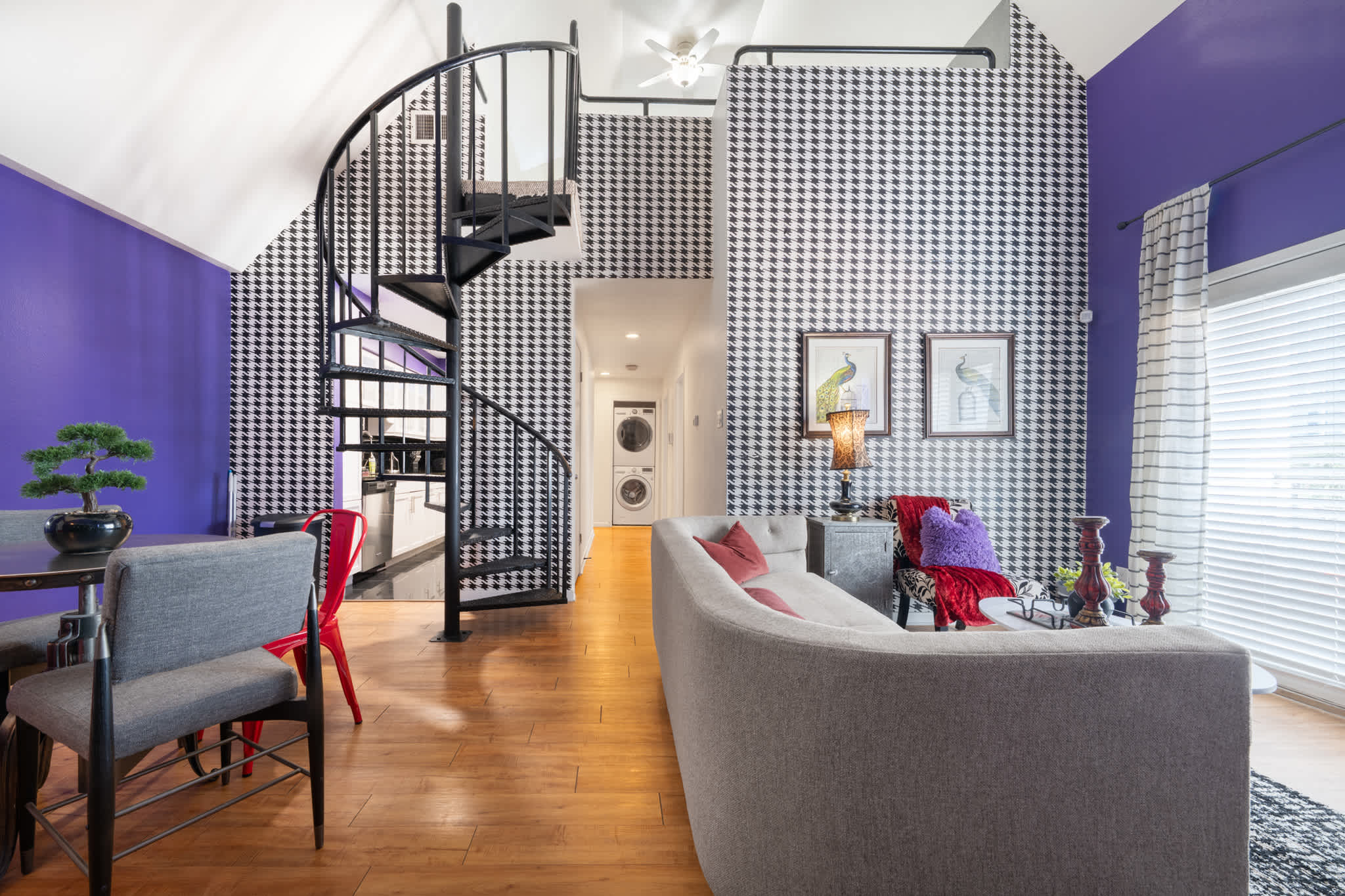 Stylish living space with a spiral staircase and bold decor, perfect for relaxation and entertainment.