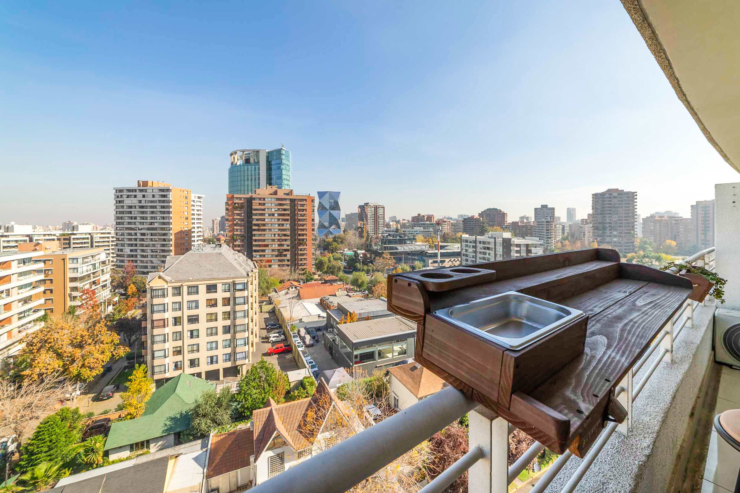 Private balcony with a wooden hot tub and sweeping views across Santiago’s skyline.
