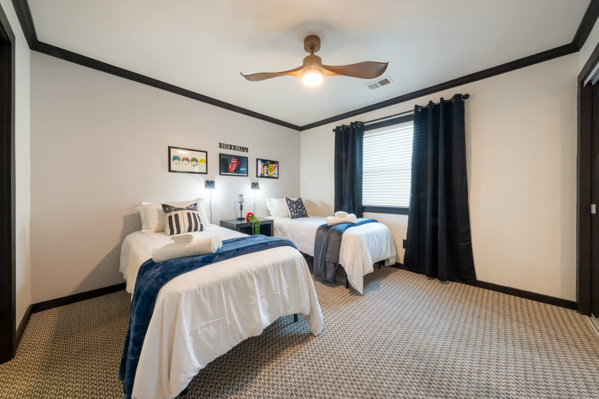 Cozy twin bedroom with stylish decor and ample natural light, perfect for a relaxing stay.