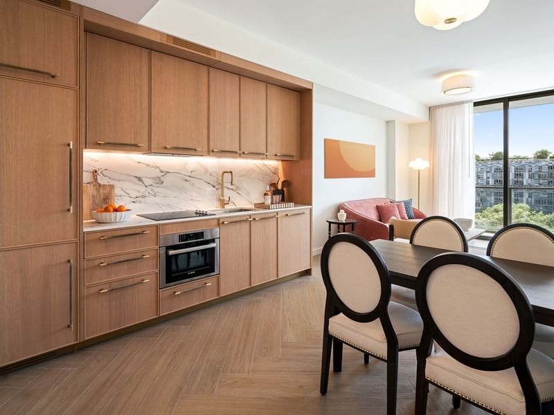 Experience modern living with a stylish kitchen and cozy seating area, all bathed in natural light from expansive windows.