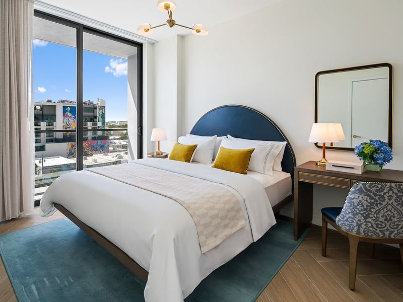 Relax in this stylish bedroom with city views, featuring a plush king-sized bed and elegant decor.