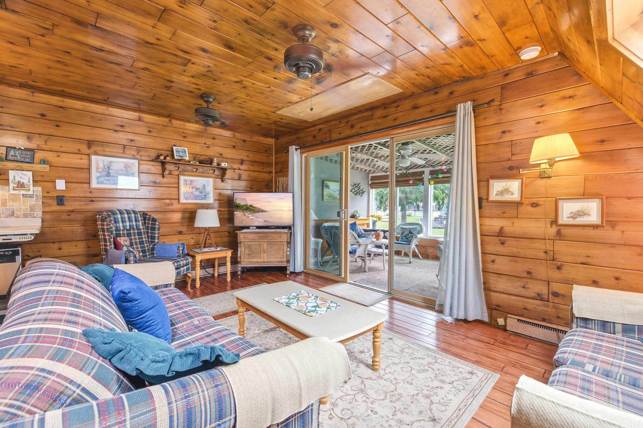 Living room opens to a screened porch overlooking resort amenities.