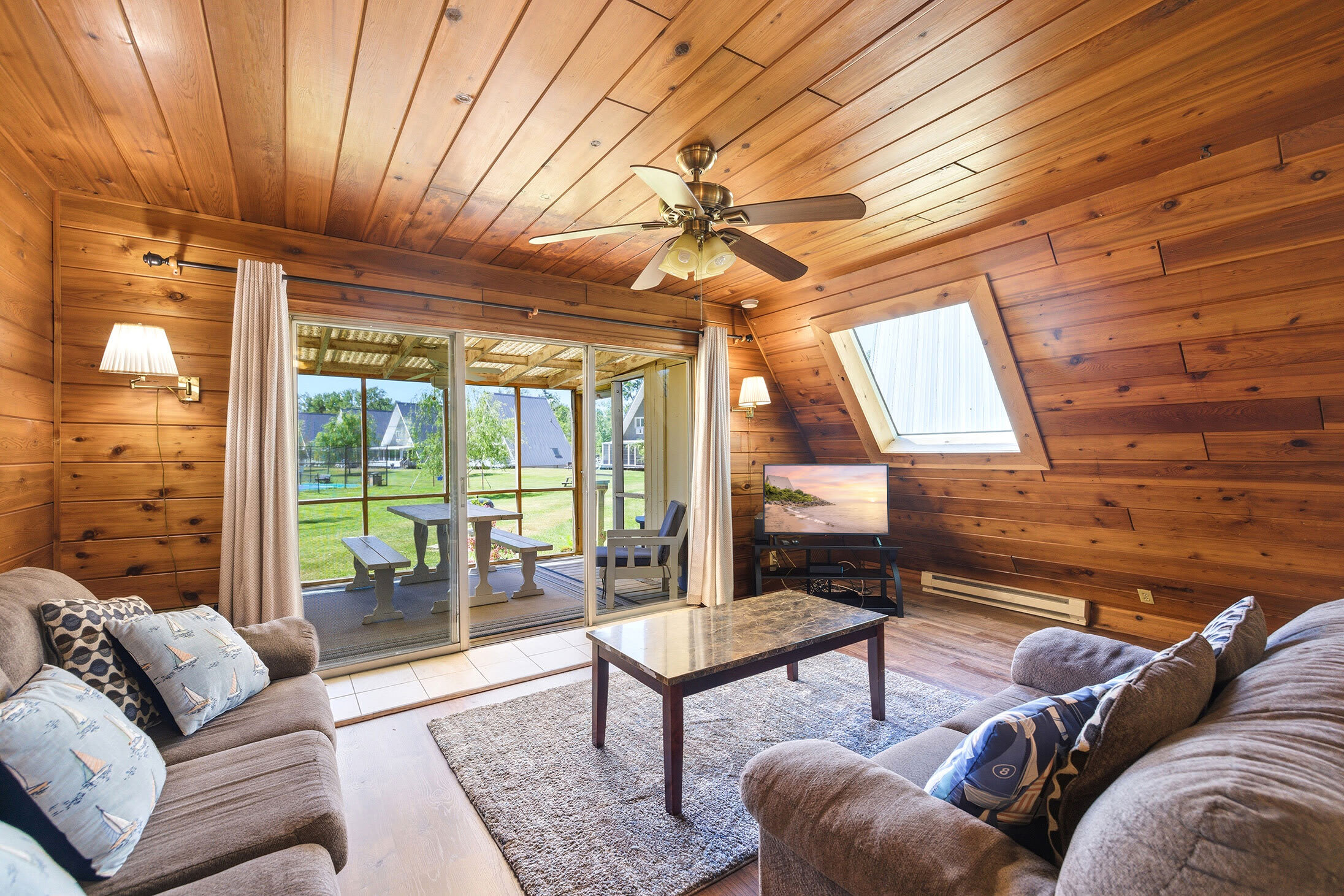 Kick back in the cozy living room with a TV and easy access to the screened porch.
