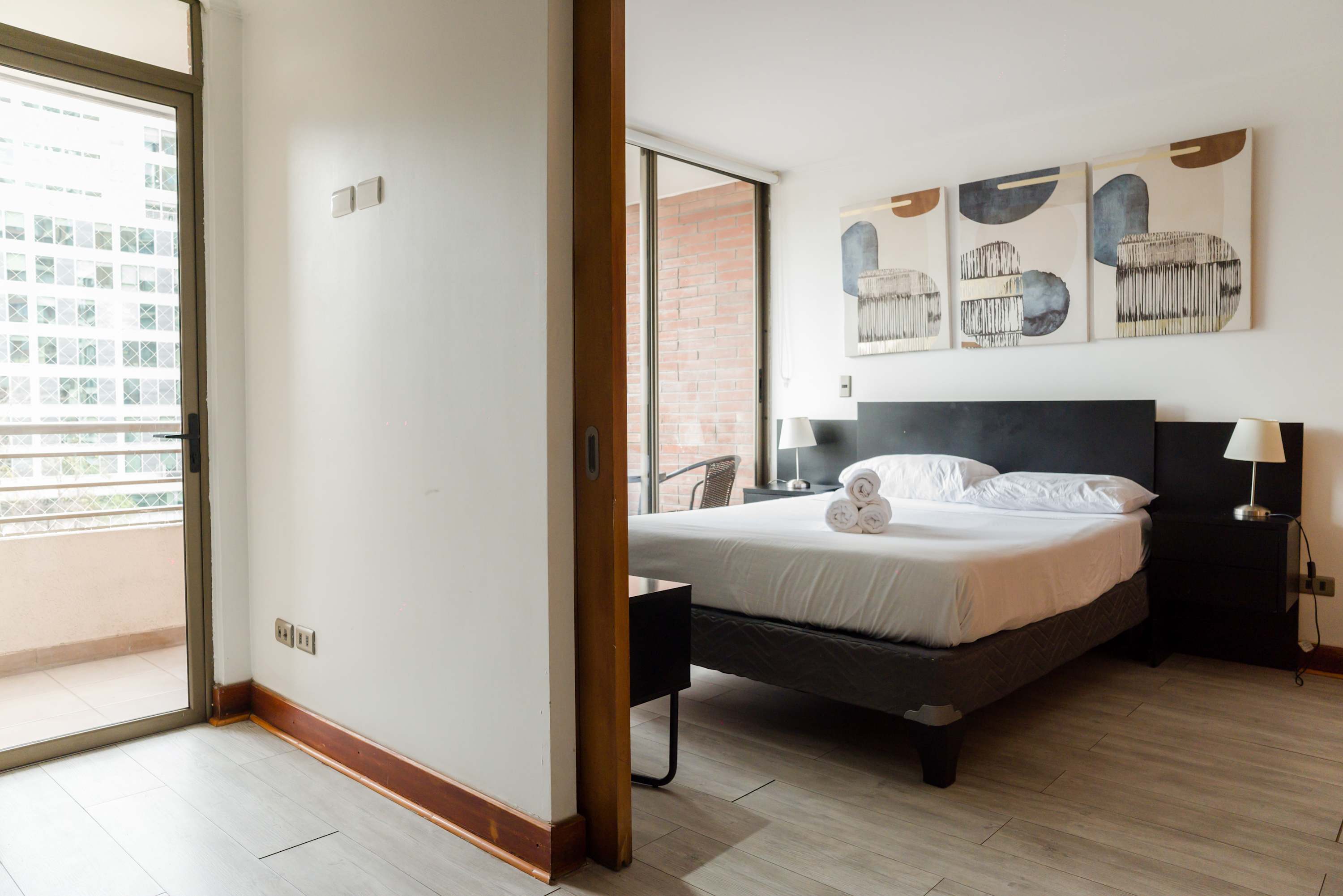 Cozy bedroom with balcony access and modern decor, perfect for a relaxing stay.