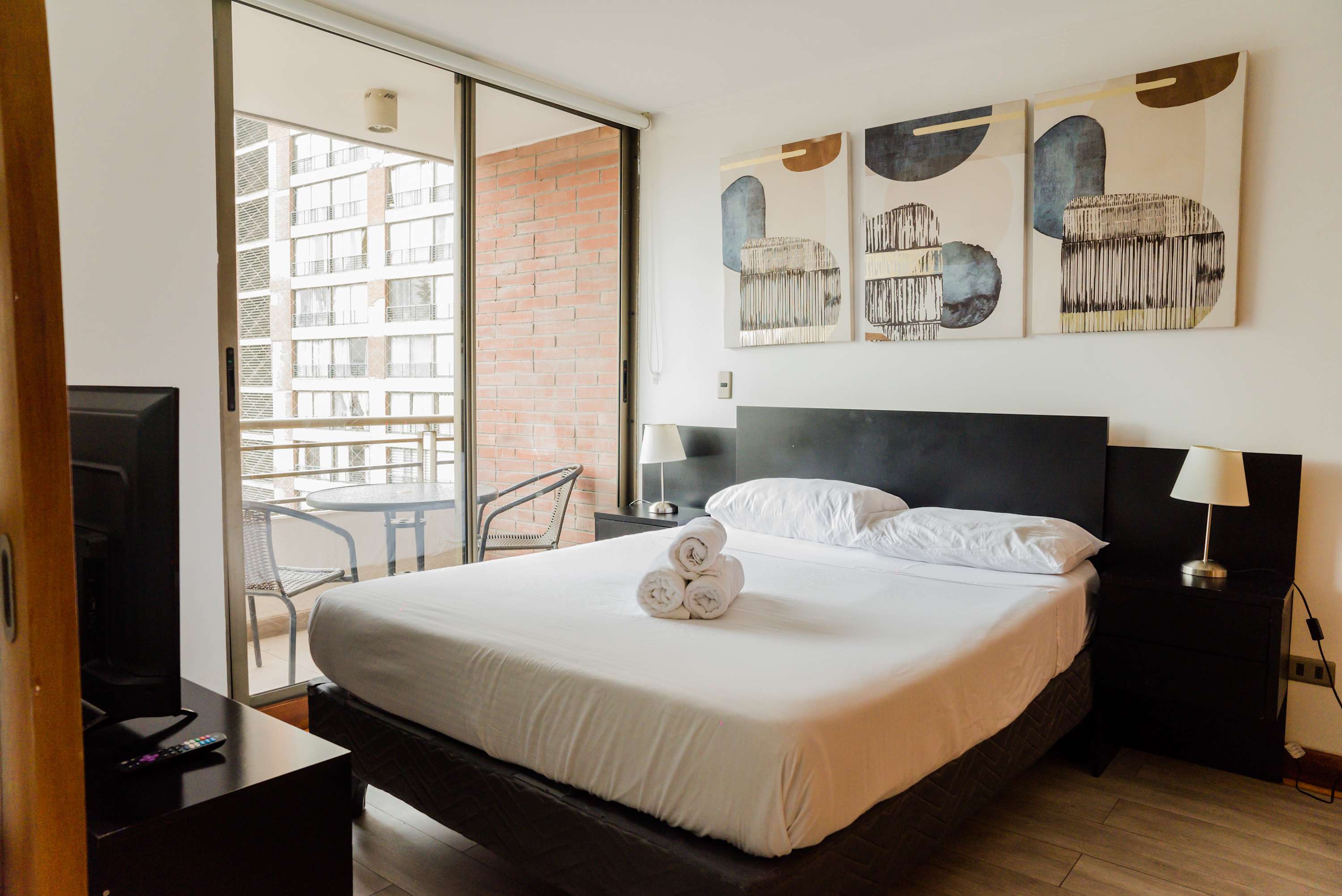 Cozy bedroom with balcony access, perfect for enjoying city views and relaxation.